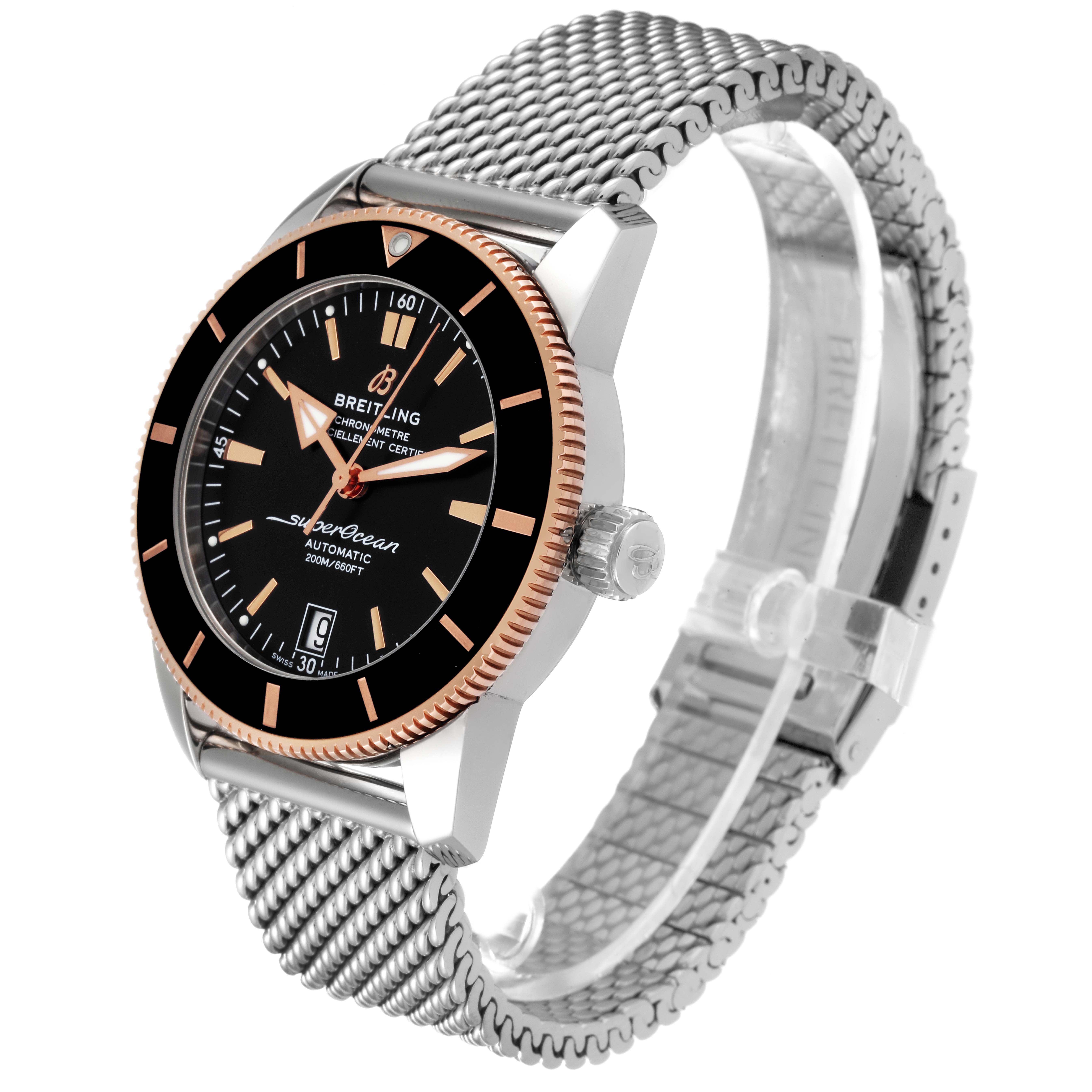 The image shows a Breitling Superocean UB2010 Men's Steel and Gold (two tone) Black Dial UB2010 Men's Steel and Gold (two tone) Black Dial model watch at a three-quarter angle, highlighting the dial, bezel, crown, and mesh strap.