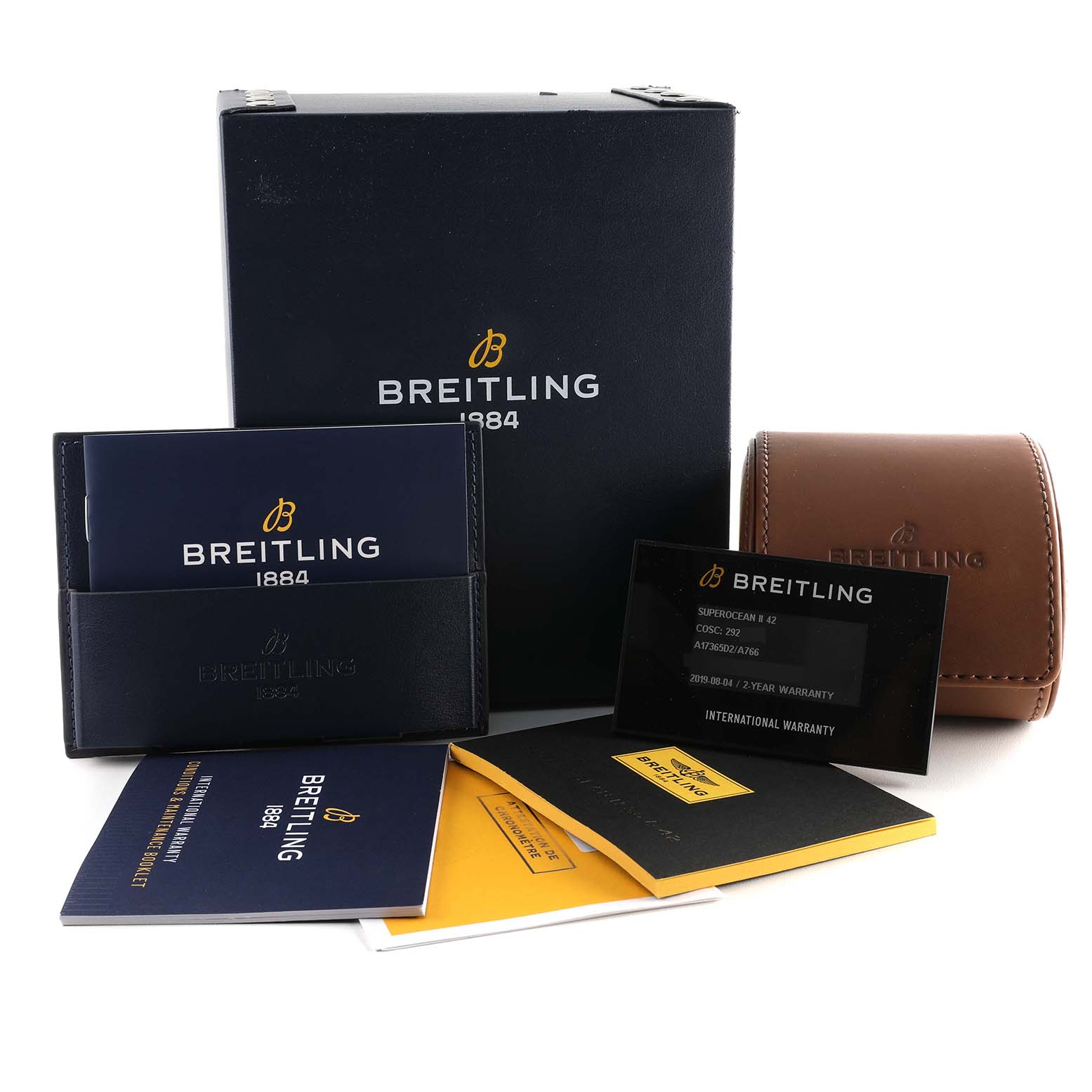 The image shows accessories for a Breitling Superocean A17365 Men's Stainless Steel White Dial A17365 Men's Stainless Steel White Dial watch, including packaging, manuals, warranty cards, and a leather case.