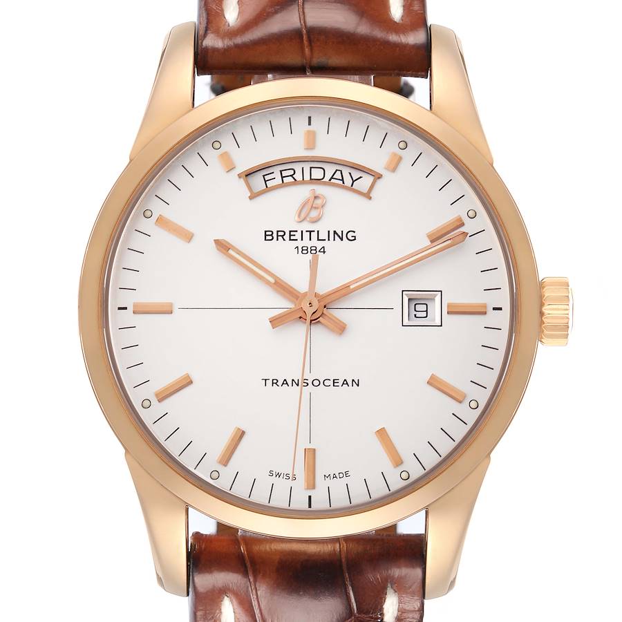 The image shows a frontal view of the Breitling Transocean model R45310, highlighting its gold case, white dial, brown leather strap, day, and date features.