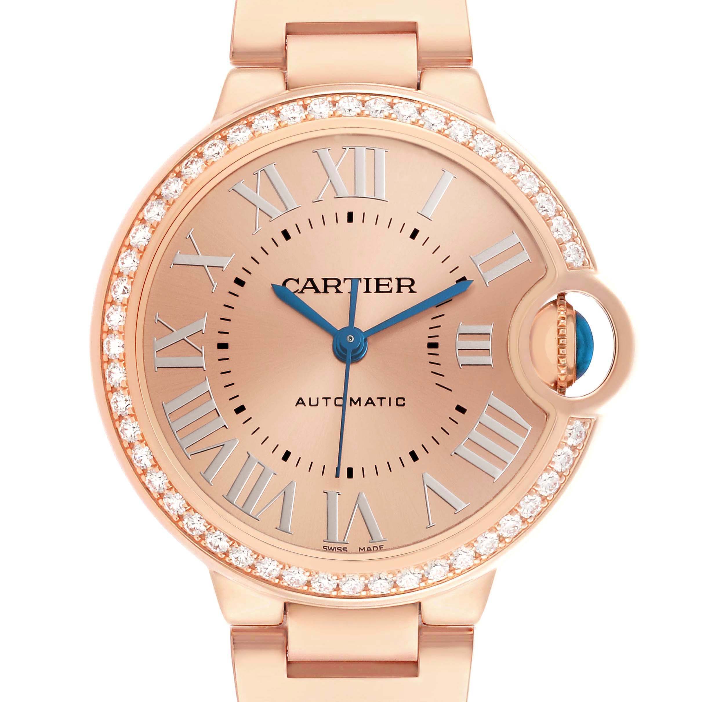 The Cartier Ballon Bleu WJBB0077 Women's Yellow Gold Pink Dial watch is shown from the front, featuring a round dial with Roman numerals, blue hands, and a diamond-set bezel.