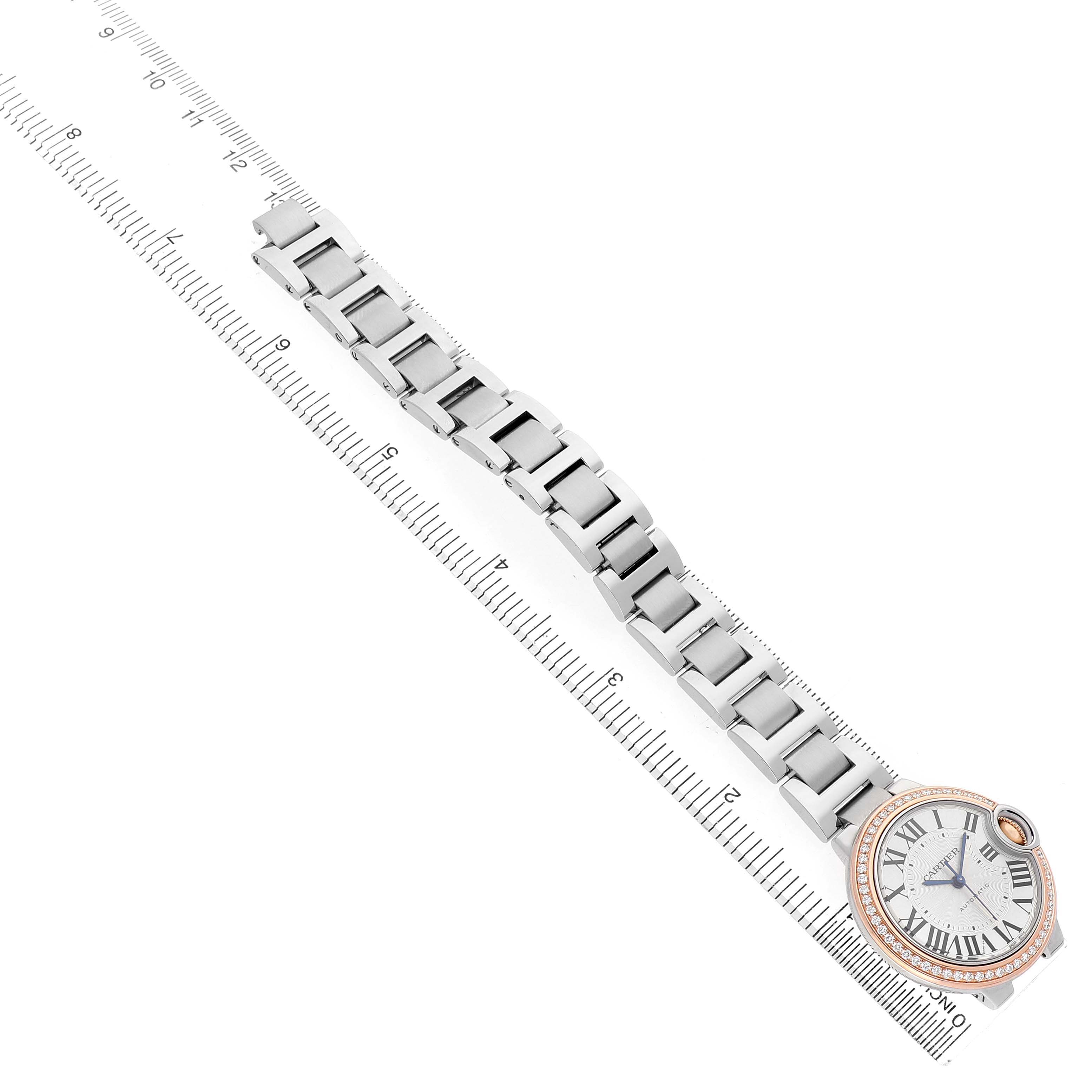 The image shows a top view of a Cartier Ballon Bleu WE902080 Women's Steel and Gold (two tone) Silver Dial watch with its bracelet aligned next to a ruler.