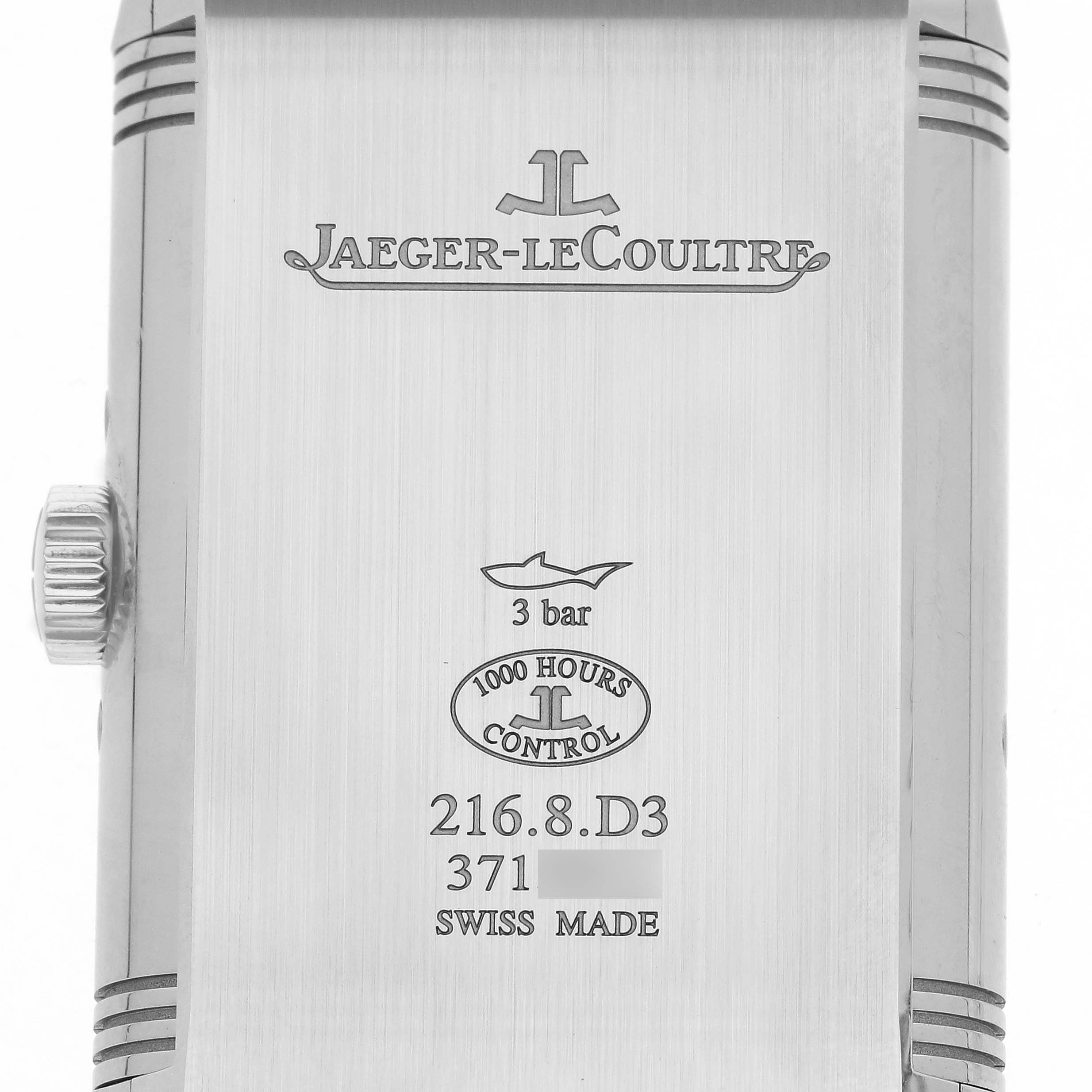 The image shows the back of the Jaeger-LeCoultre Reverso watch, including its crown and engraved details.