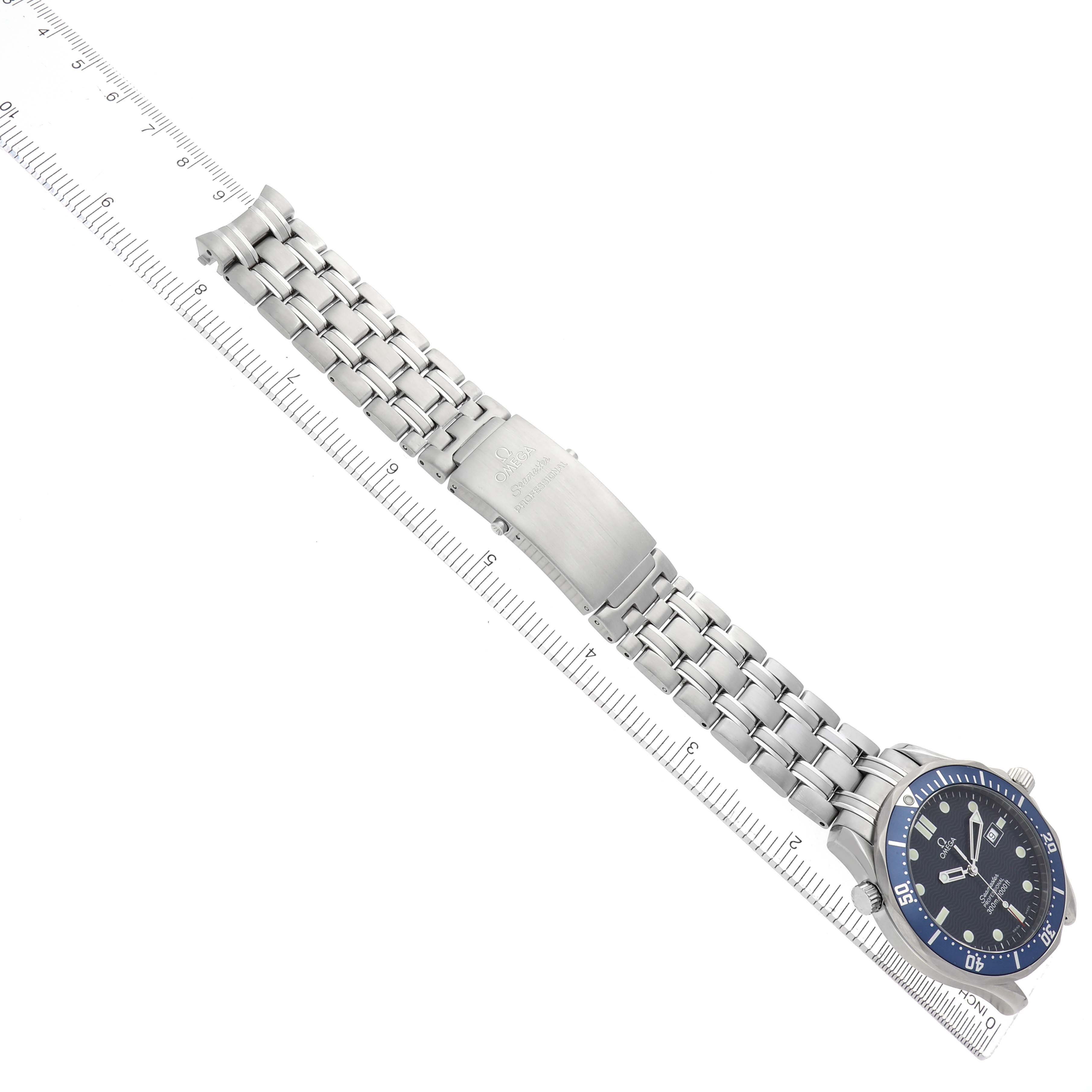The Omega Seamaster 2541.80.00 Men
s Stainless Steel Blue Dial watch is shown at a slight angle, highlighting the bracelet and clasp alongside a ruler for scale.