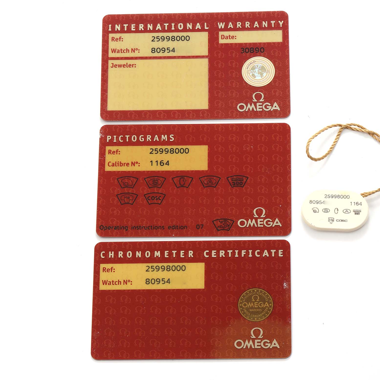 The image shows three Omega Seamaster 2599.80.00 Men
s Stainless Steel Blue Dial cards: International Warranty, Pictograms, Chronometer Certificate, and a tag with reference details.