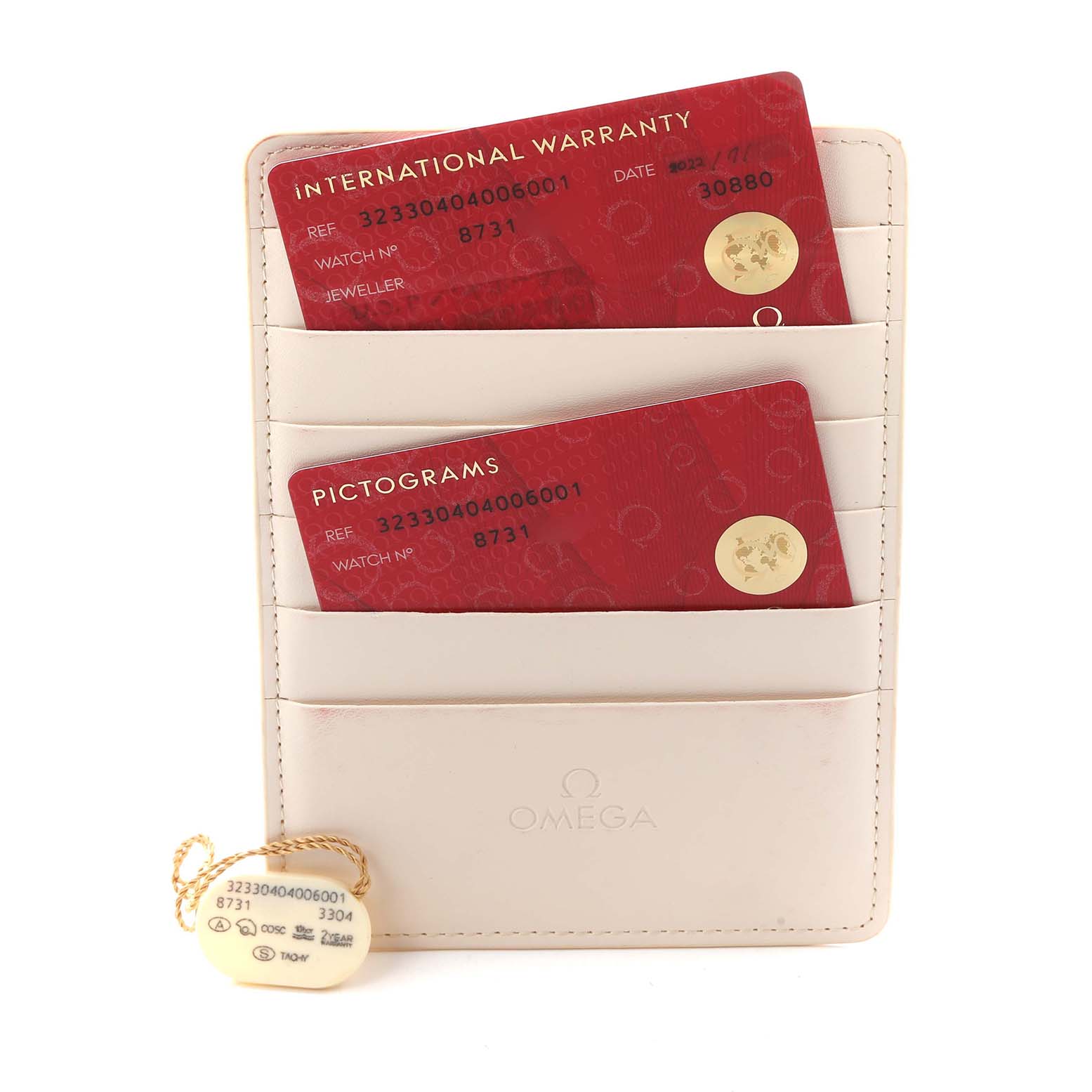 The image shows Omega Speedmaster 323.30.40.40.06.001 Men
s Stainless Steel Grey Dial model
s international warranty and pictogram cards in a cardholder, with a tag attached.