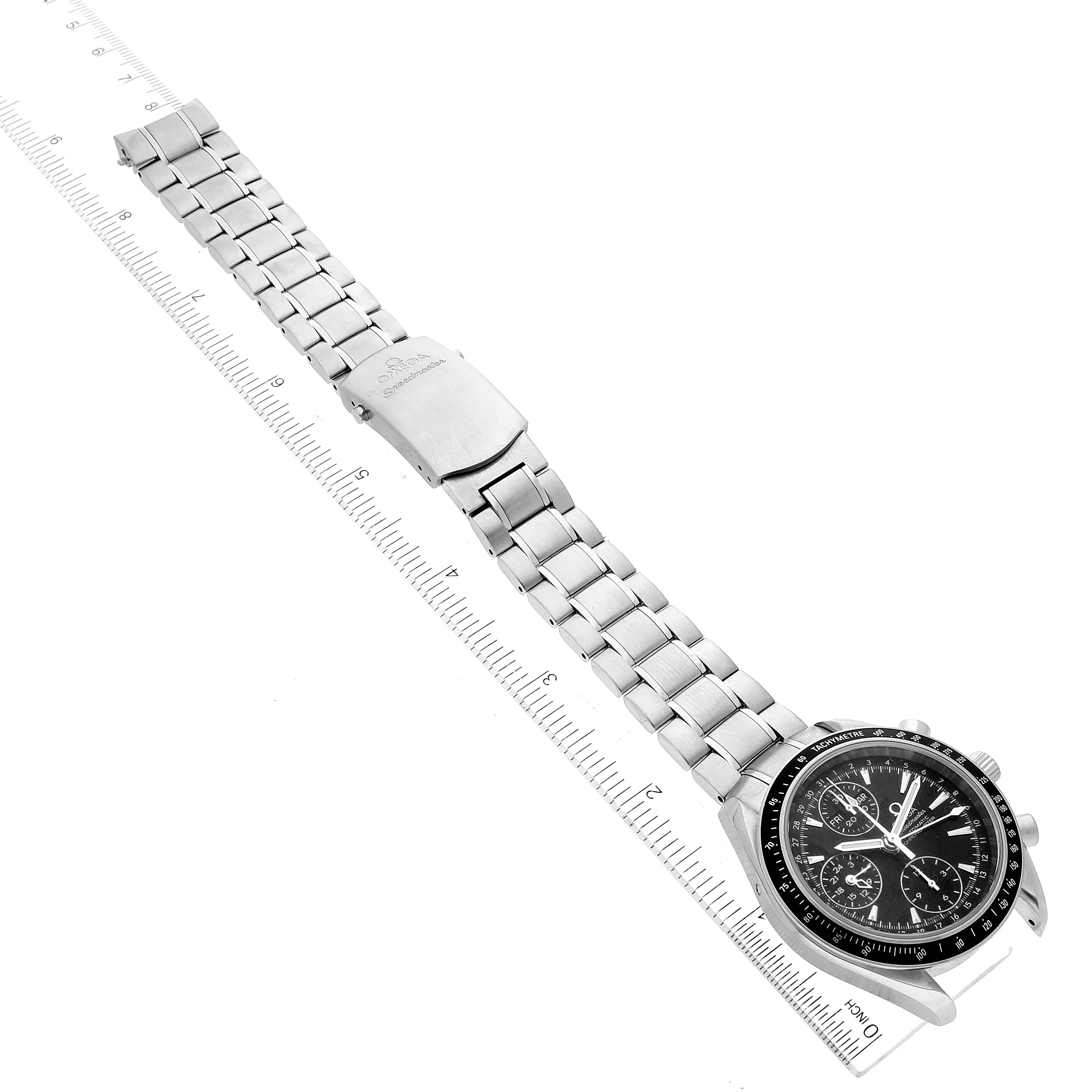 The image shows an Omega Speedmaster 3220.50.00 Men
s Stainless Steel Black Dial 3220.50.00 Men
s Stainless Steel Black Dial watch laid flat, including the face, bezel, and metal bracelet, positioned alongside a measuring ruler.