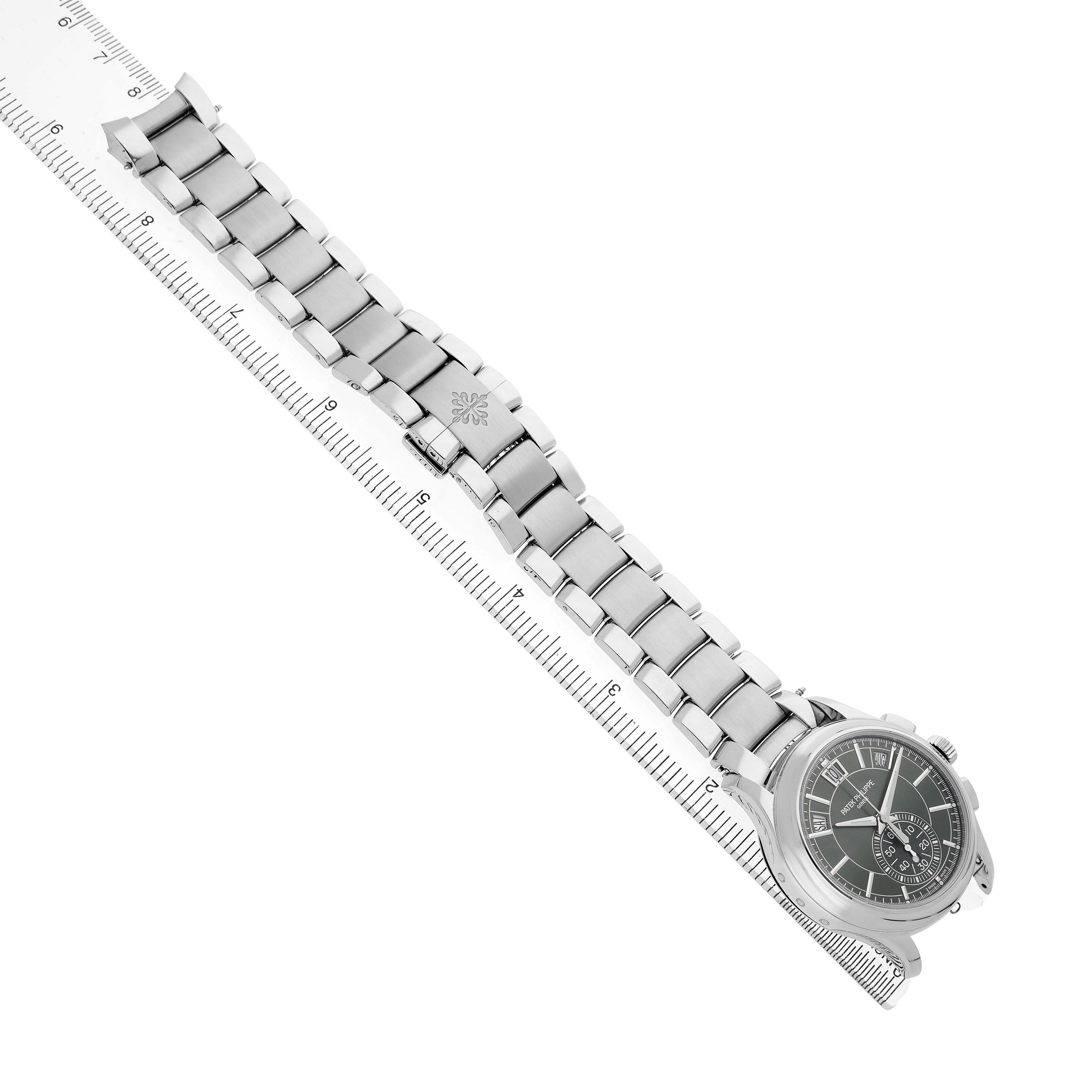 The Patek Philippe Complications 5905/1A-001 Men's Stainless Steel Green Dial watch is shown diagonally, displaying the bracelet and dial on a ruler background.