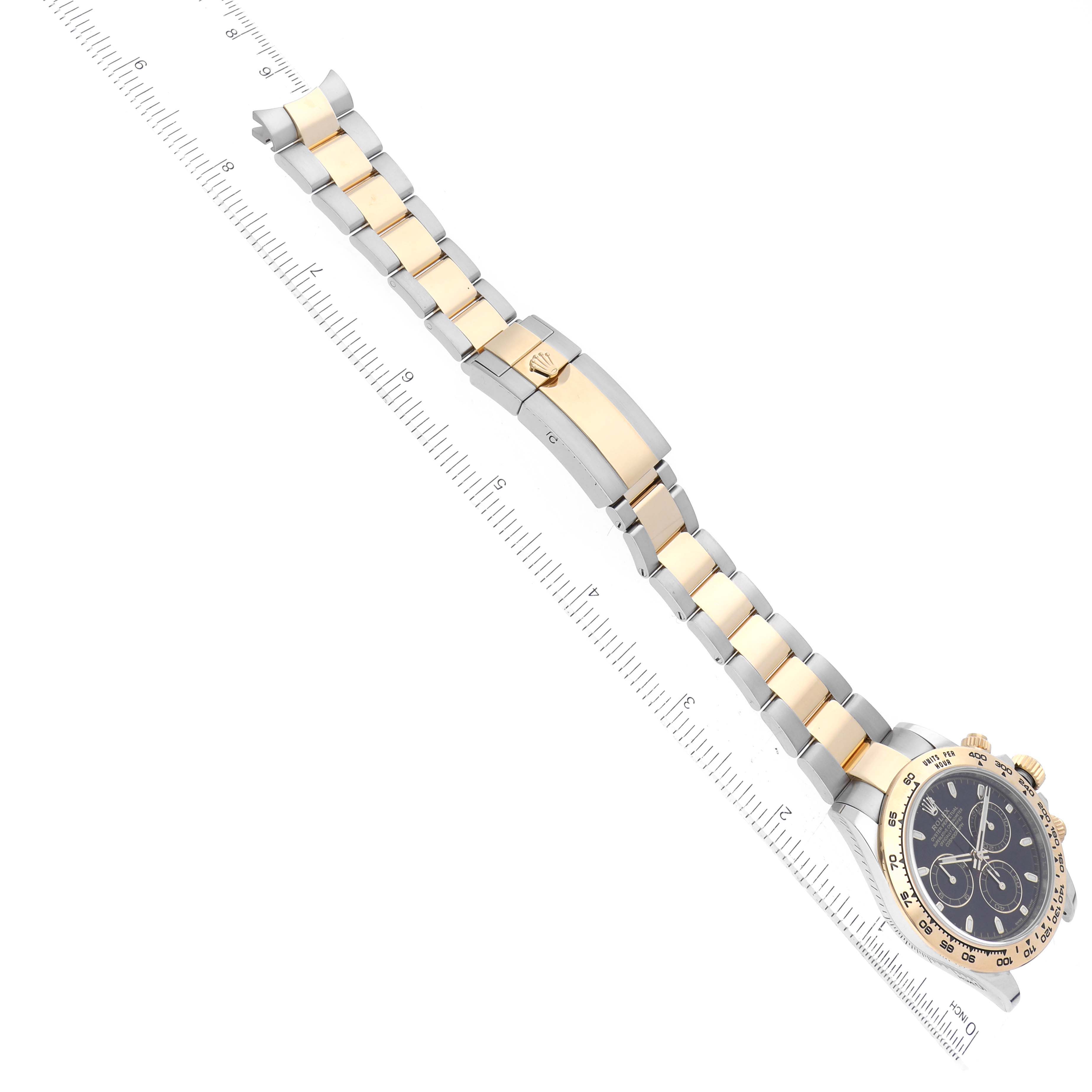 The image shows a Rolex Daytona 116503 Men's Steel and Gold (two tone) Black Dial 116503 Men's Steel and Gold (two tone) Black Dial watch at a top-down angle, highlighting the band and clasp alongside a ruler for scale.