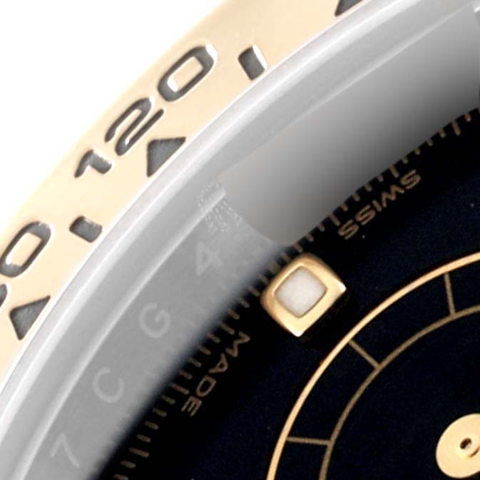 This closeup image shows the bezel and part of the dial of a Rolex Daytona 116503 Men's Steel and Gold (two tone) Black Dial 116503 Men's Steel and Gold (two tone) Black Dial watch.