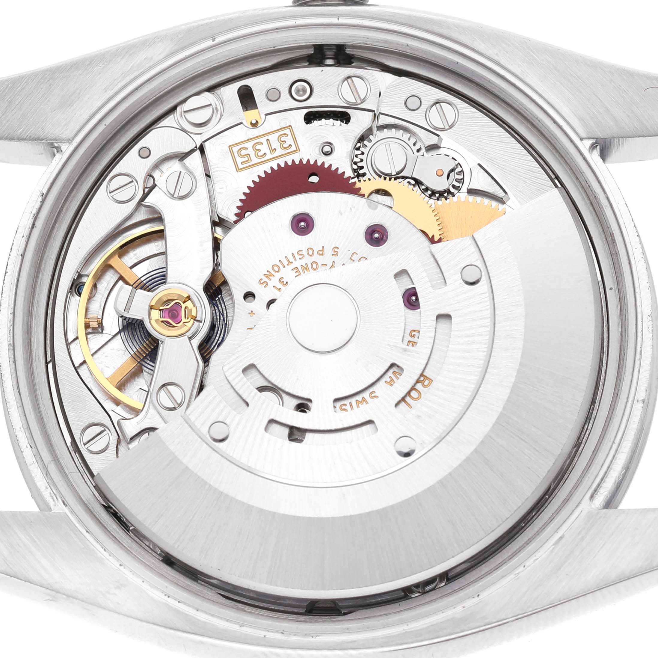 The image shows the movement of a Rolex Date 115200 Men's Stainless Steel Black Dial watch model viewed from the back, highlighting its intricate mechanical parts.