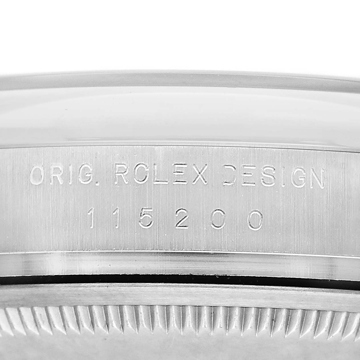 The image shows the side view of a Rolex Date 115200 Men's Stainless Steel Black Dial model, focusing on the engraved bezel.