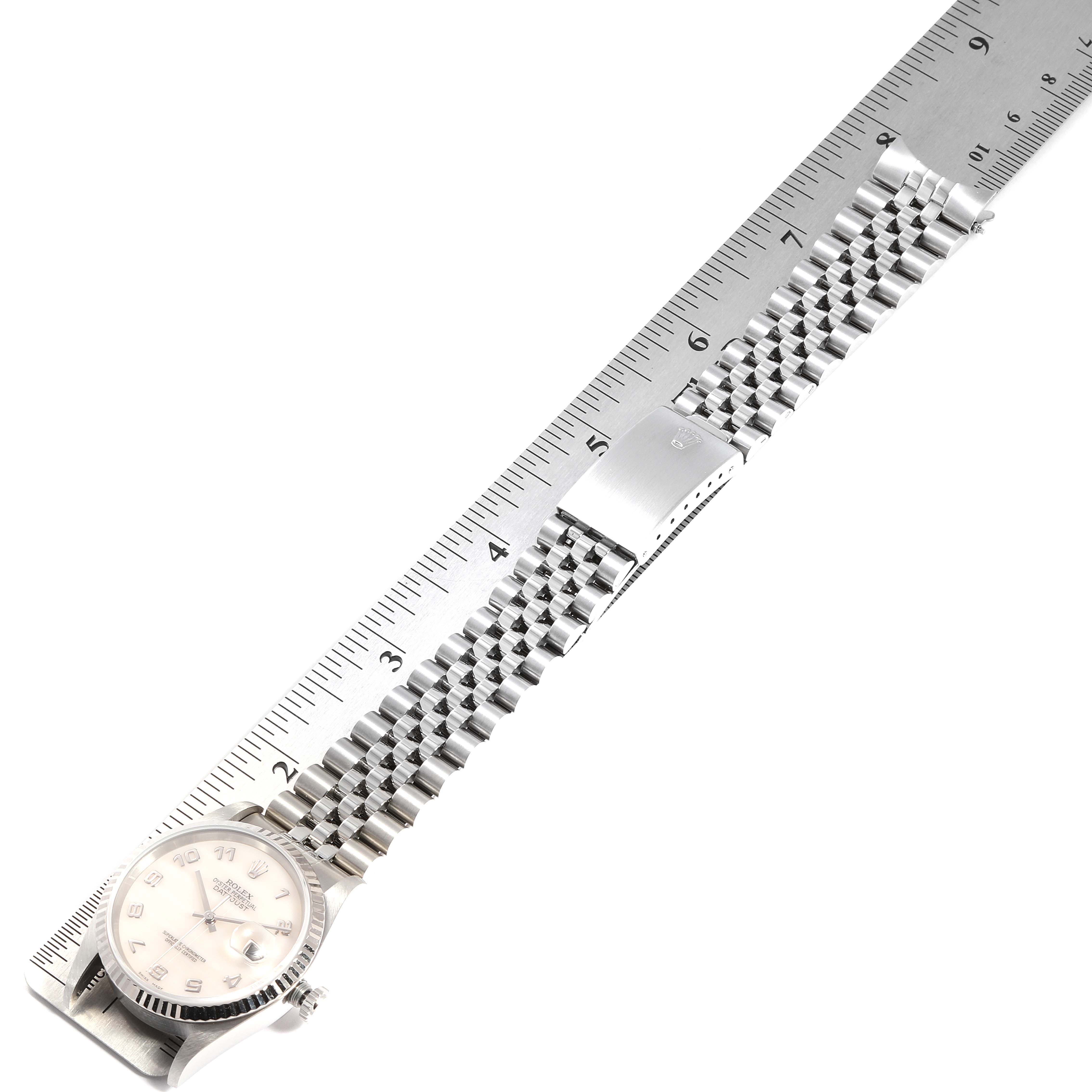 The image shows a Rolex Datejust 16234 Men
s Stainless Steel Mother of Pearl Dial 16234 Men
s Stainless Steel Mother of Pearl Dial watch laid flat with the bracelet and dial alongside a ruler.