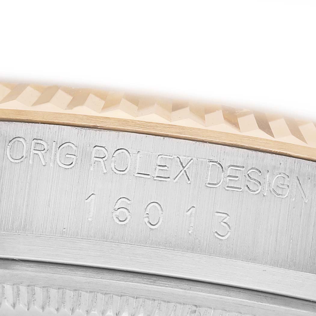 The image shows a close-up of the Rolex Datejust 16013 Men's Steel and Gold (two tone) Champagne Dial model's engraved case, featuring the design and model number.