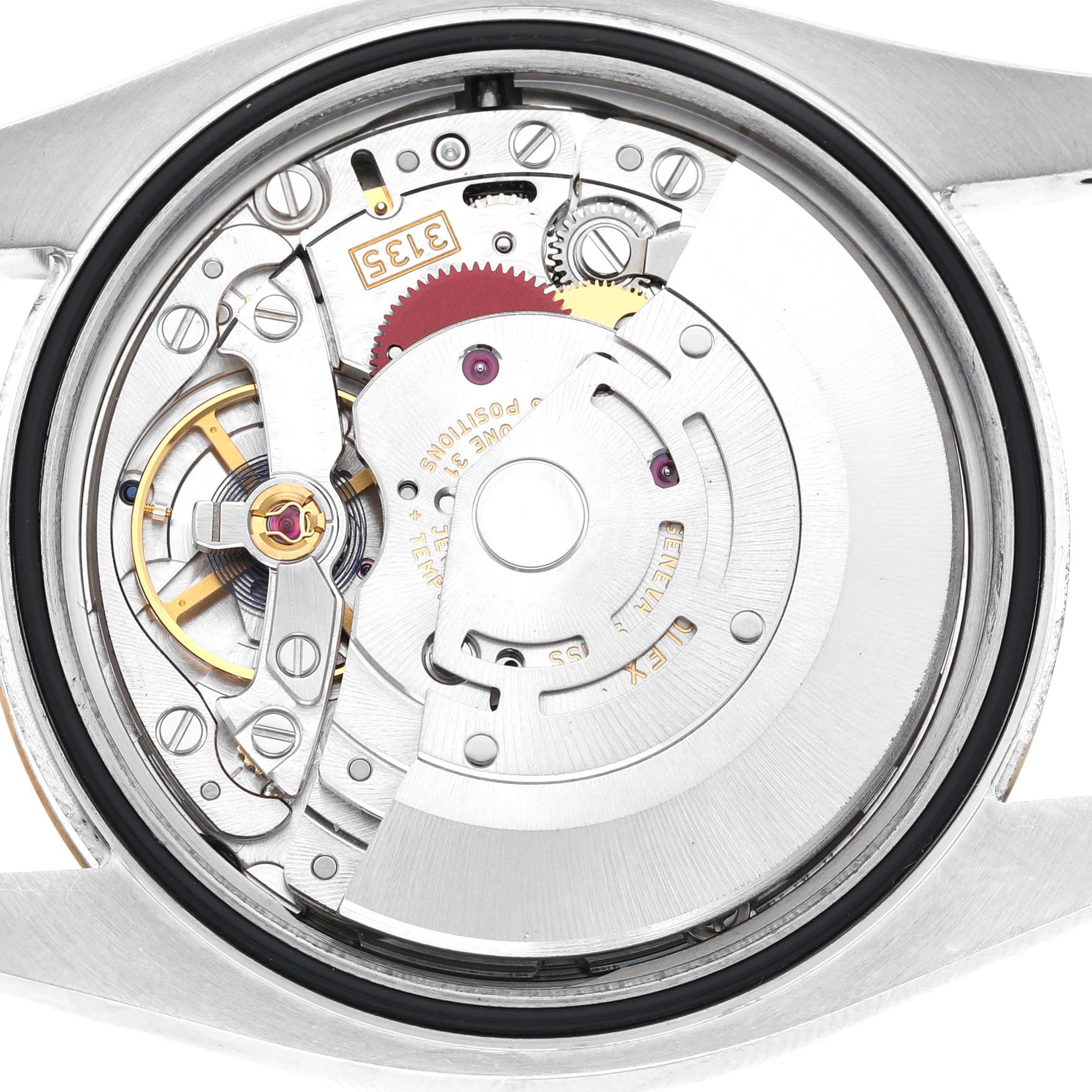 The image shows the Rolex Datejust 116233 Men's Steel and Gold (two tone) Silver Dial's inner mechanism and movement from a back view, highlighting the intricate gears and components.