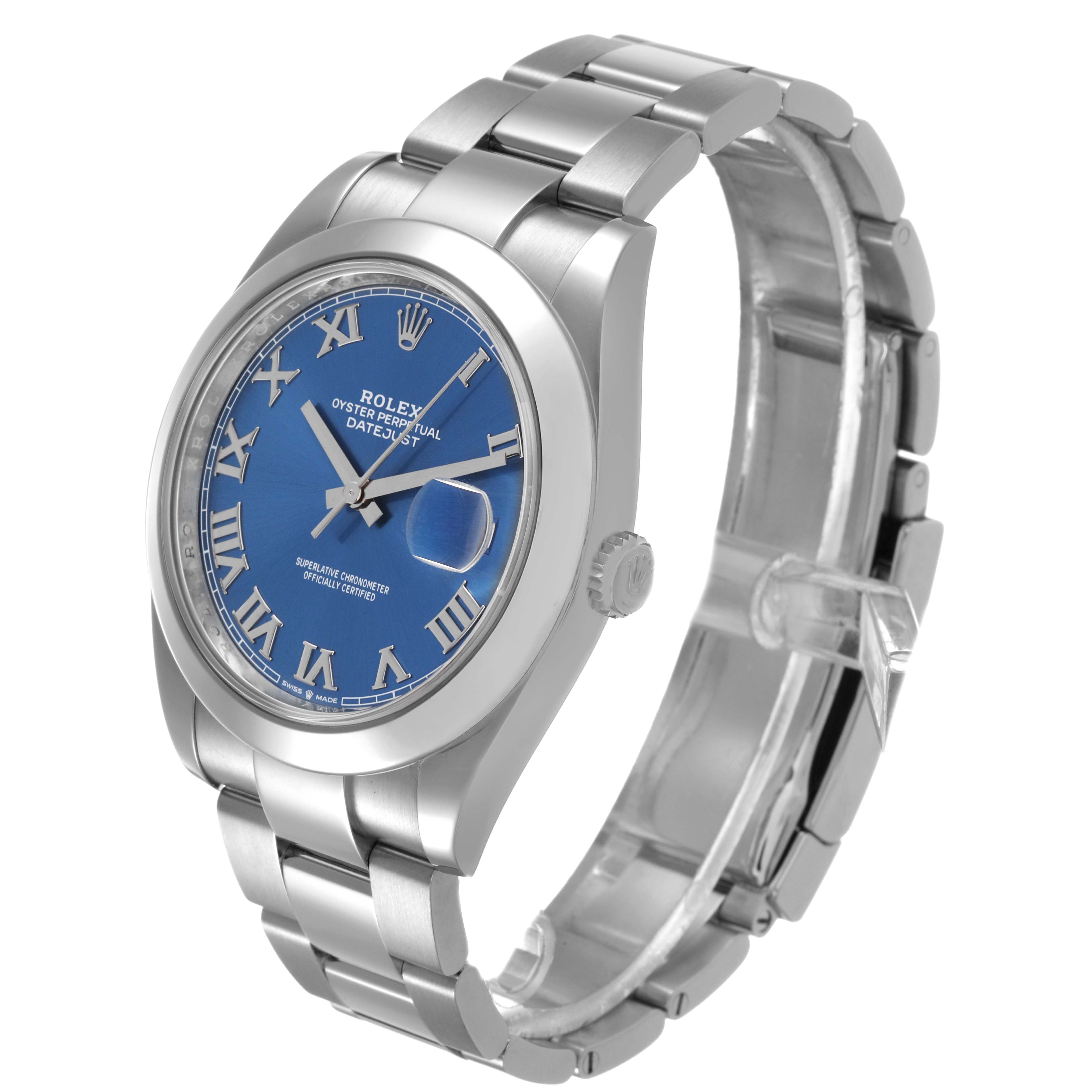 The image shows a Rolex Datejust 126300 Men's Stainless Steel Blue Dial watch at a three-quarter angle, highlighting the blue dial, Roman numerals, and the bracelet.