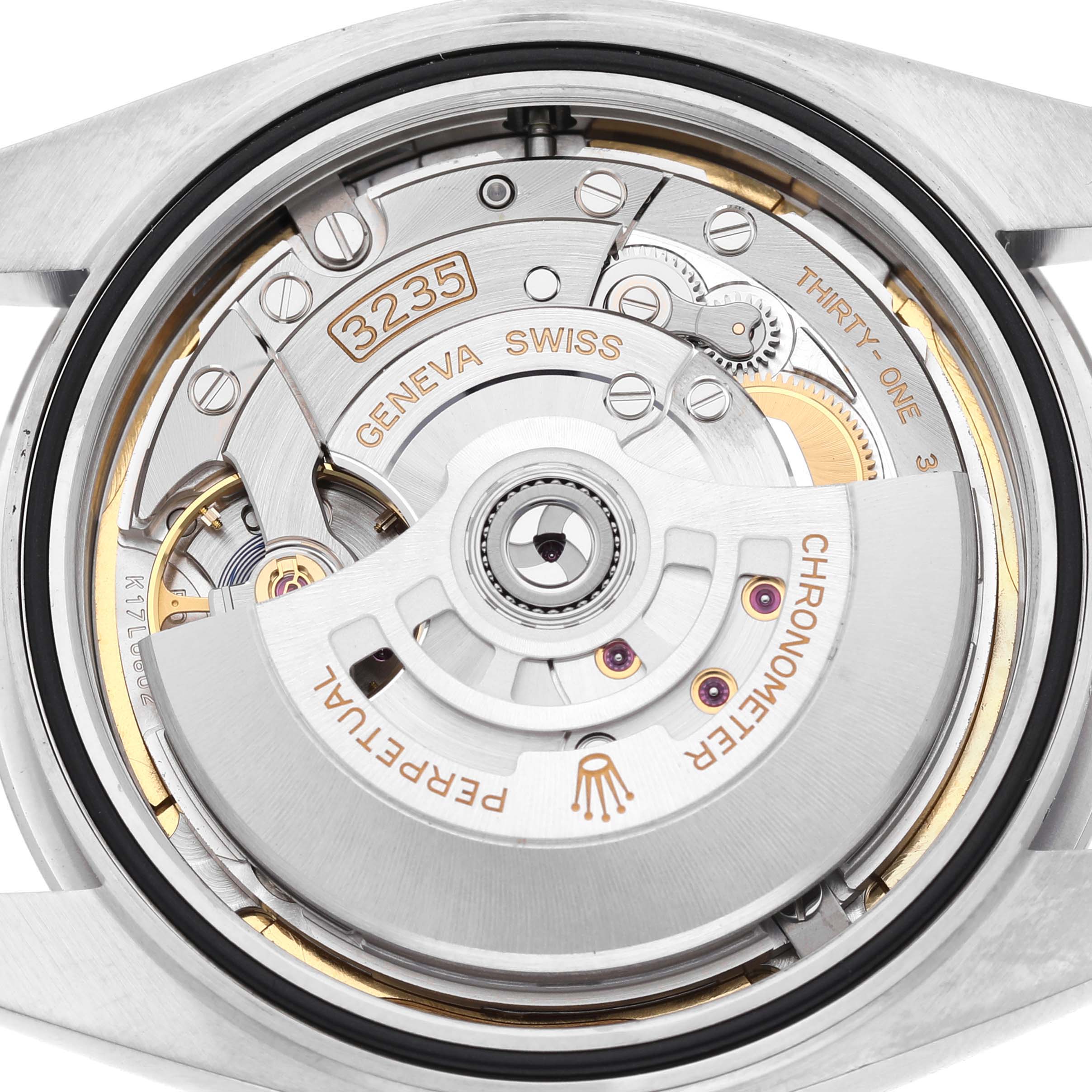 The image shows the movement of a Rolex Datejust 126300 Men's Stainless Steel Blue Dial watch from a back angle, highlighting its rotor and intricate components.