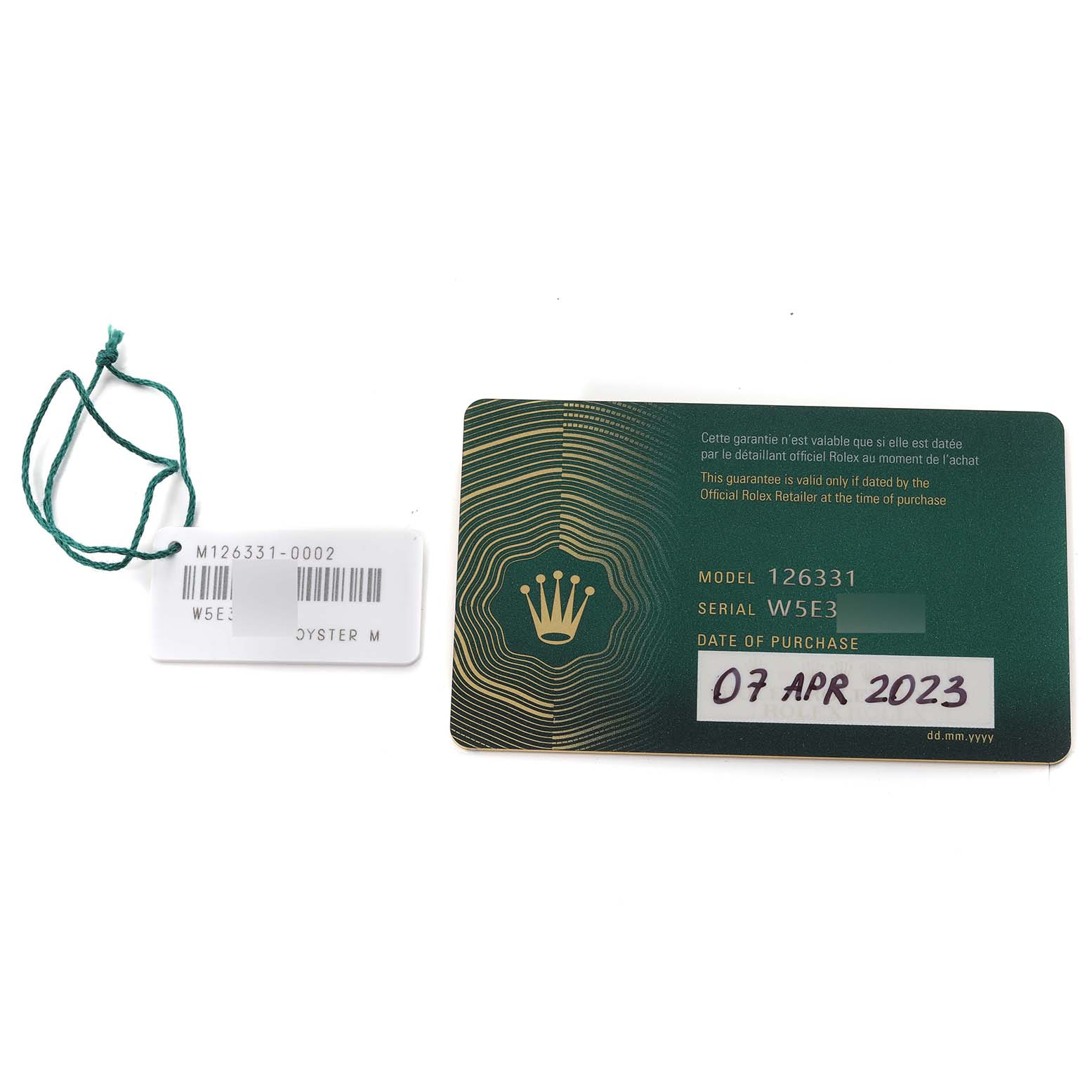 This image shows the warranty card and a tag for the Rolex Datejust 41 126331 Men's Steel and Gold (two tone) Brown Dial 126331 Men's Steel and Gold (two tone) Brown Dial, model 126331, serial W5E3.