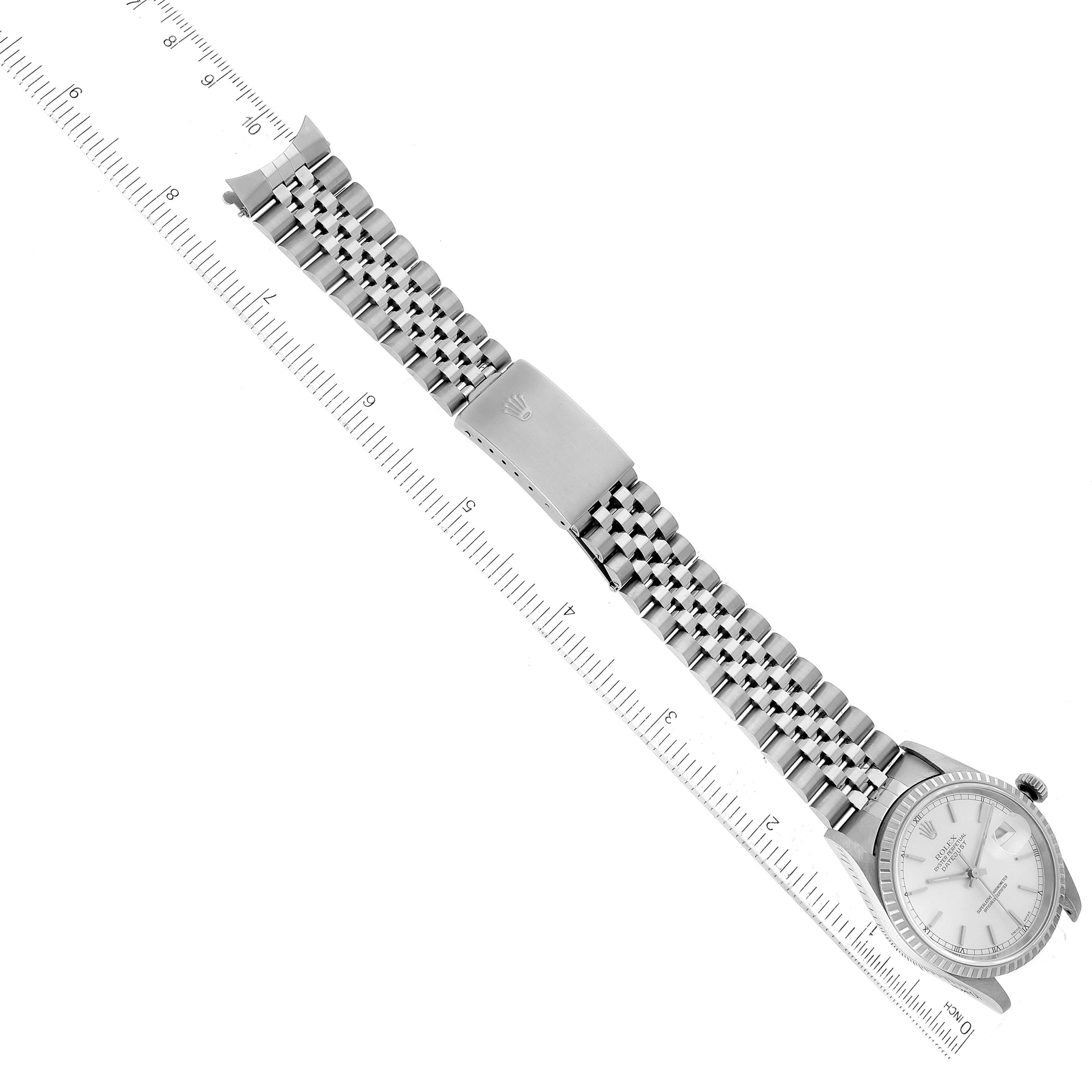 The Rolex Datejust 16220 Men's Stainless Steel Silver Dial 16220 Men's Stainless Steel Silver Dial watch is shown from the side with the full bracelet and clasp, measured alongside a ruler.