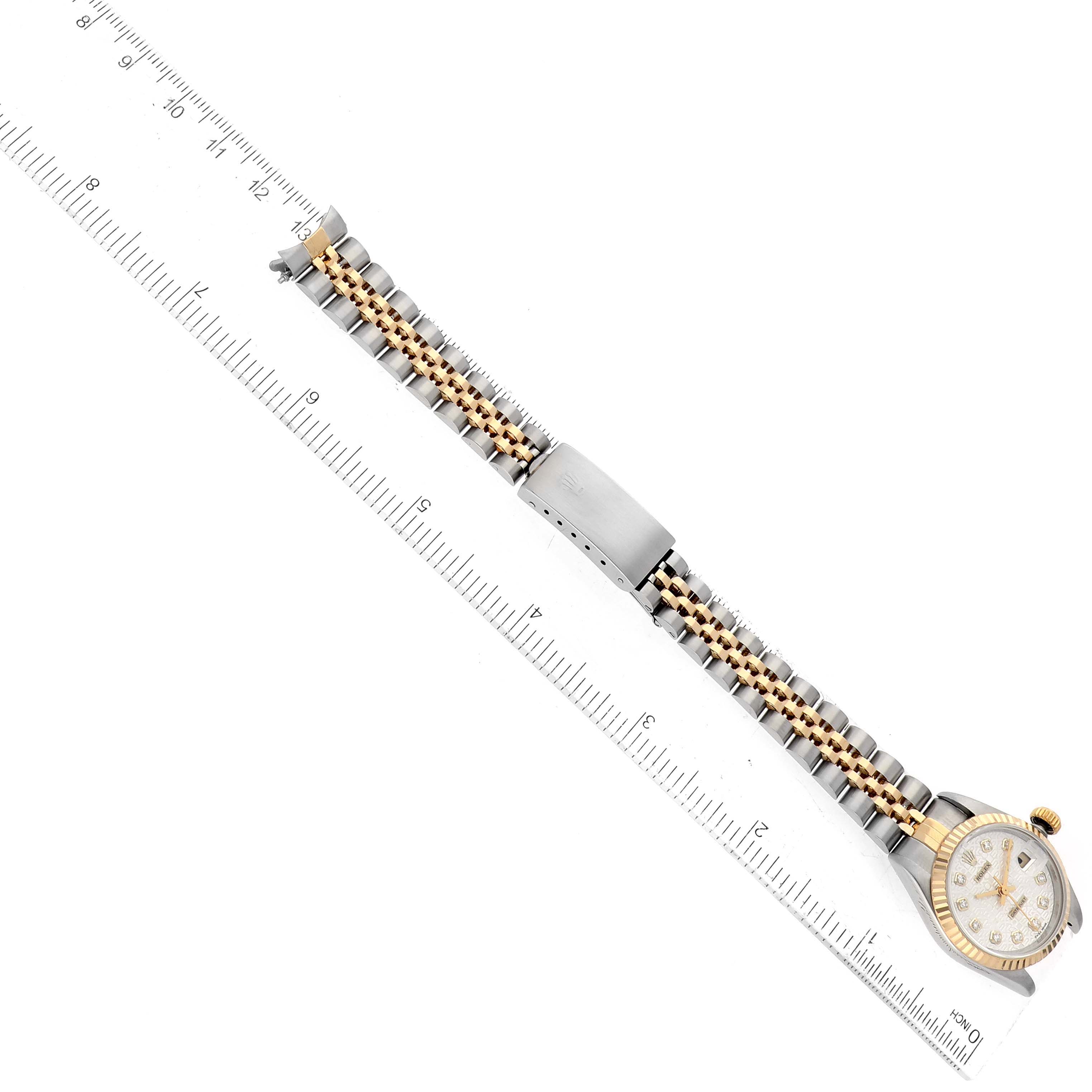 This is an overhead view of the Rolex Datejust 69173 Women's Steel and Gold (two tone) Silver Dial 69173 Women's Steel and Gold (two tone) Silver Dial watch featuring the entire bracelet and watch face, with a ruler for scale.