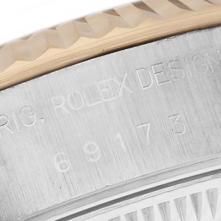 This image shows a close-up of the bezel and engraving on the side case of a Rolex Datejust 69173 Women's Steel and Gold (two tone) Silver Dial 69173 Women's Steel and Gold (two tone) Silver Dial watch.
