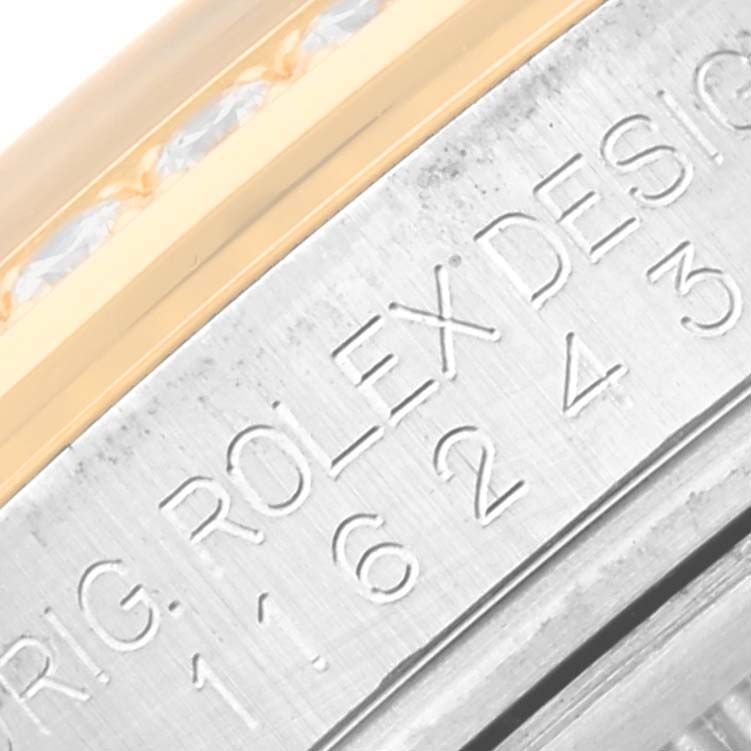 This image shows an angled close-up of the engraving on the side of the Rolex Datejust 116243 Men's Steel and Gold (two tone) Black Dial 116243 Men's Steel and Gold (two tone) Black Dial watch case.