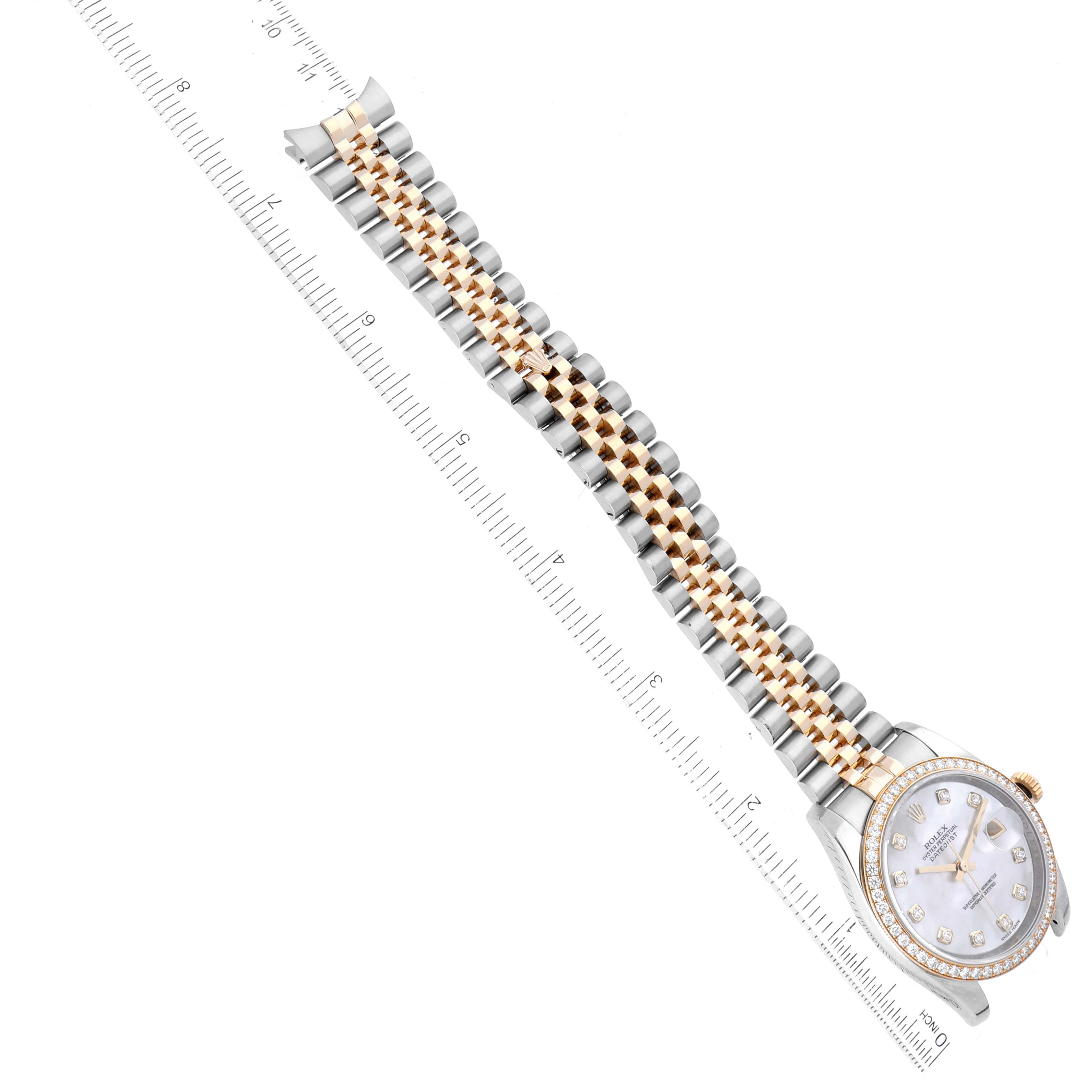 The image shows a Rolex Datejust 116243 Men's Steel and Gold (two tone) Mother of Pearl Dial 116243 Men's Steel and Gold (two tone) Mother of Pearl Dial watch angled diagonally, displaying the full bracelet and the watch face with a ruler for scale.