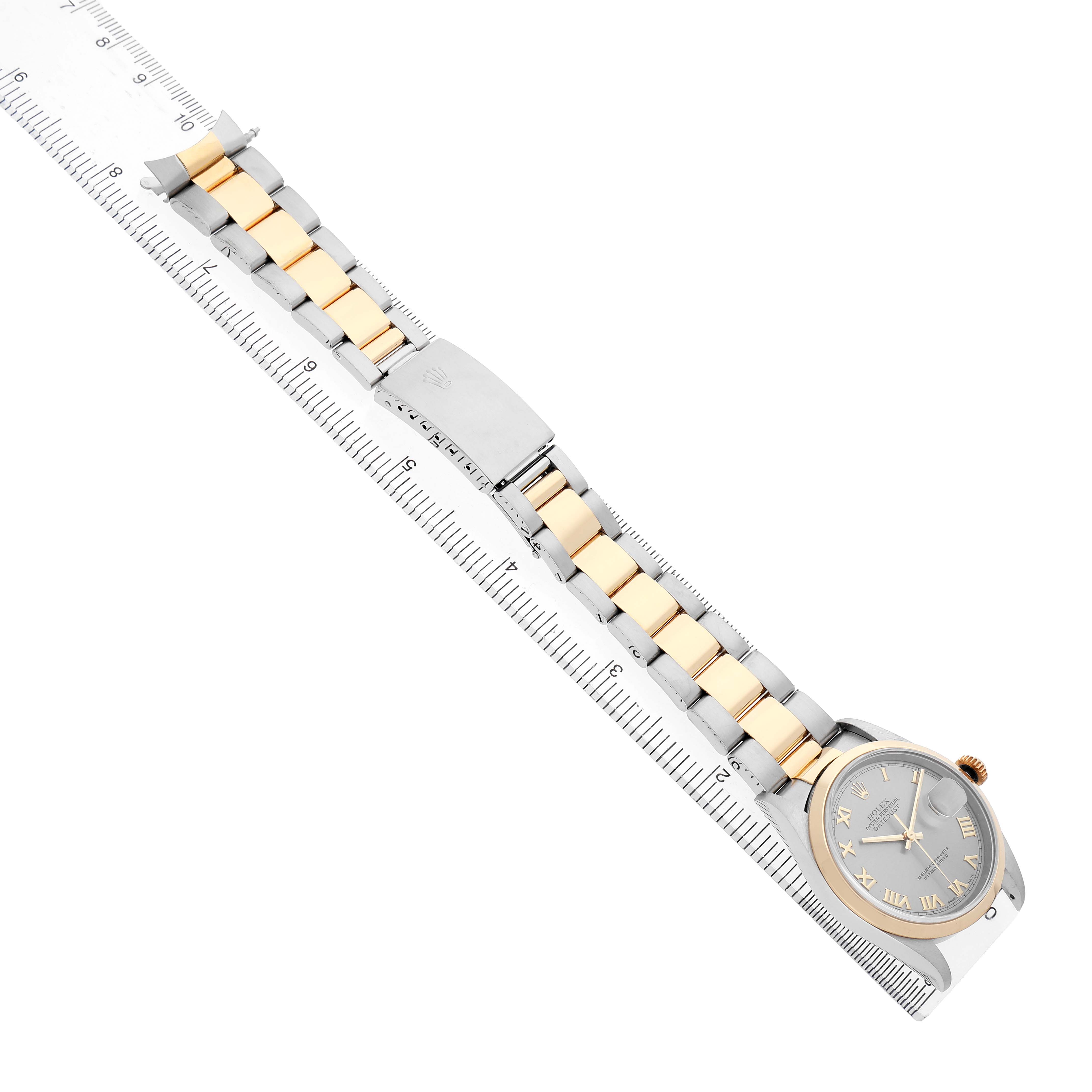 The Rolex Datejust 16203 Men's Stainless Steel Grey Dial watch is shown from a top-down angle, highlighting the band and face alongside a ruler.