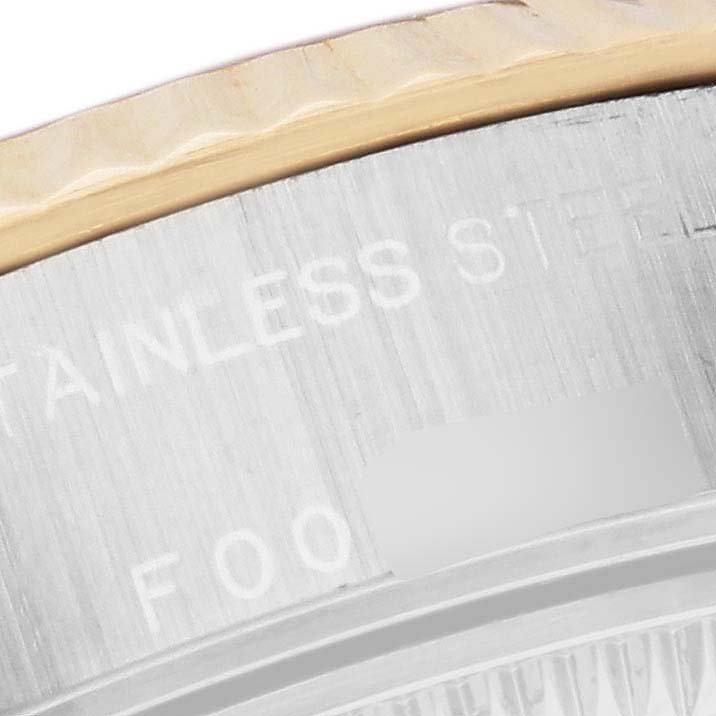 This close-up shot of the Rolex Datejust 79173 Women's Steel and Gold (two tone) White Dial 79173 Women's Steel and Gold (two tone) White Dial shows the engraved stainless steel case and part of the fluted bezel.