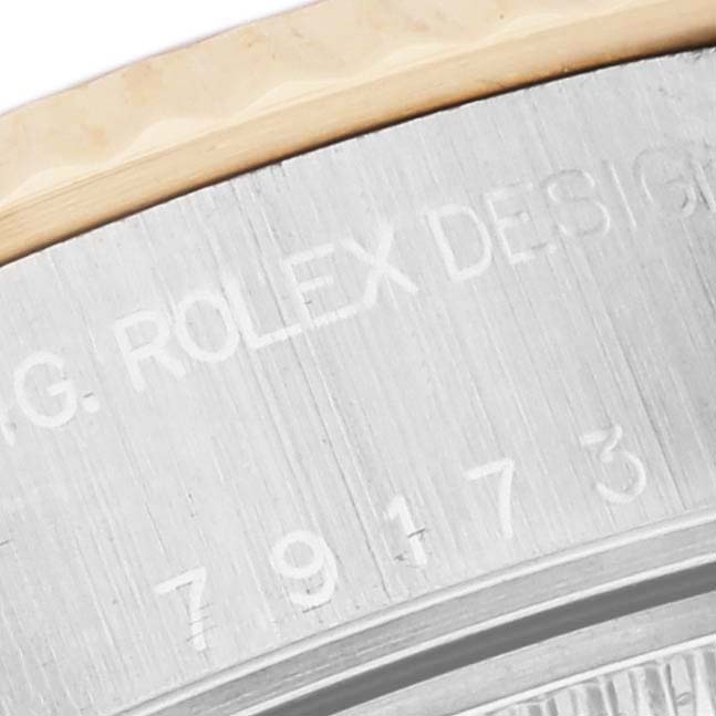 This is a close-up of the Rolex Datejust 79173 Women's Steel and Gold (two tone) White Dial 79173 Women's Steel and Gold (two tone) White Dial watch showcasing the engraved lettering and part of the bezel.