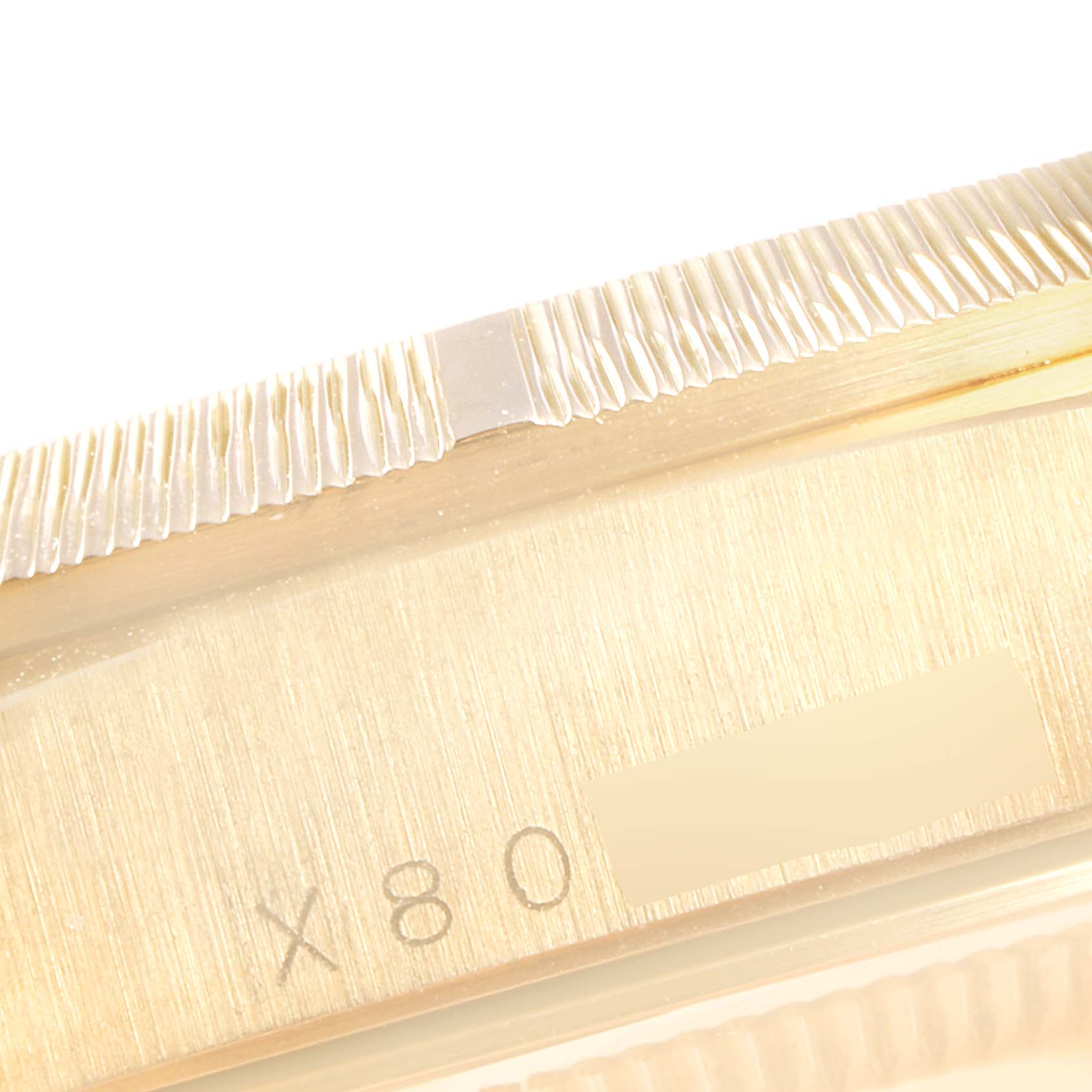 This close-up image shows the fluted bezel and part of the serial number of the Rolex President 18248 Men's Yellow Gold Beige Dial 18248 Men's Yellow Gold Beige Dial model watch.