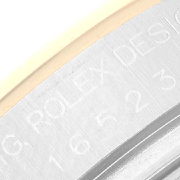 This close-up image shows the engraved serial number and "ROLEX DESIGN" text on the side of a Rolex Daytona 16523 Men
s Steel and Gold (two tone) White Dial 16523 Men
s Steel and Gold (two tone) White Dial watch case.