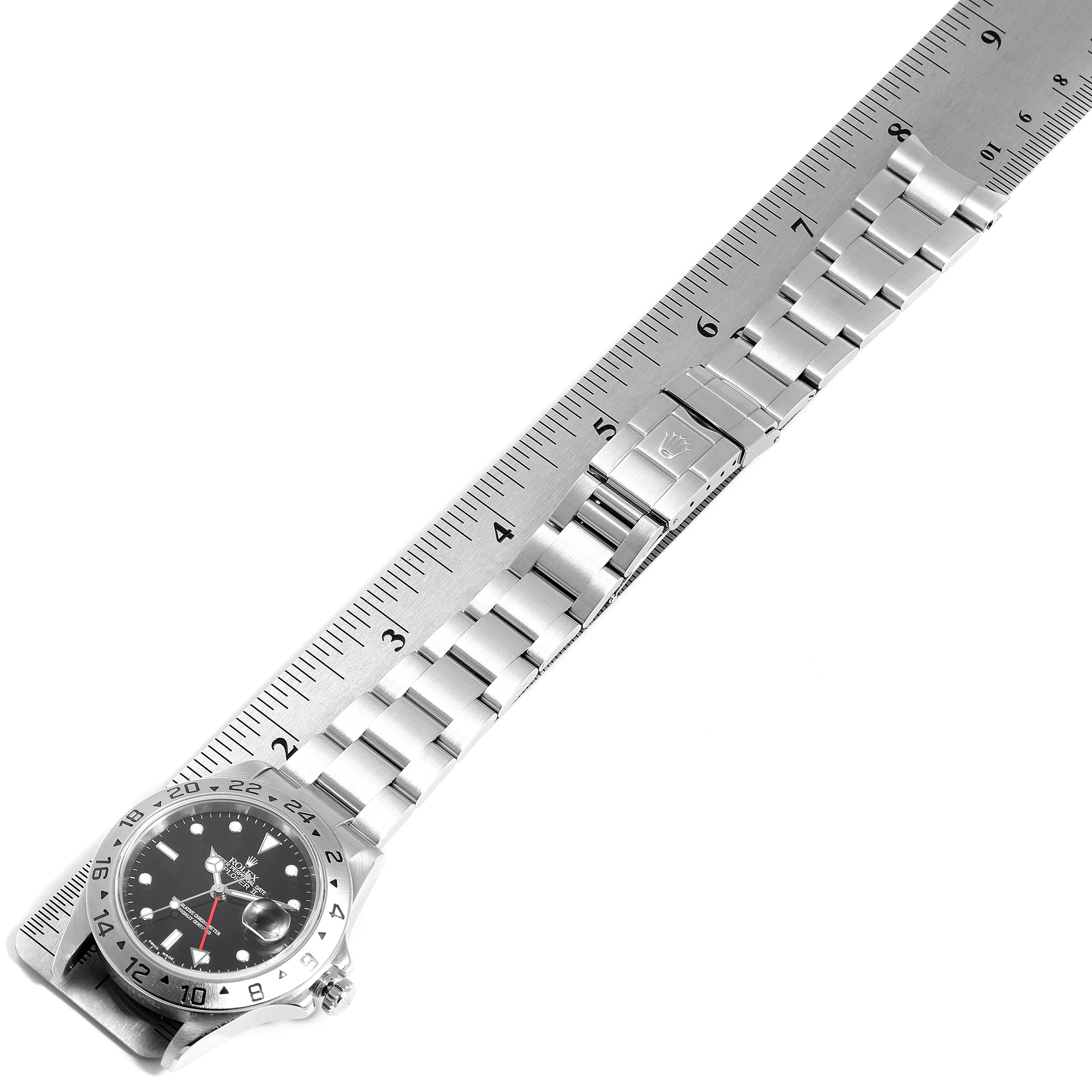 The image shows a Rolex Explorer 16570 Men
s Stainless Steel Black Dial 16570 Men
s Stainless Steel Black Dial watch laid flat alongside a ruler, showcasing the bracelet and clasp.