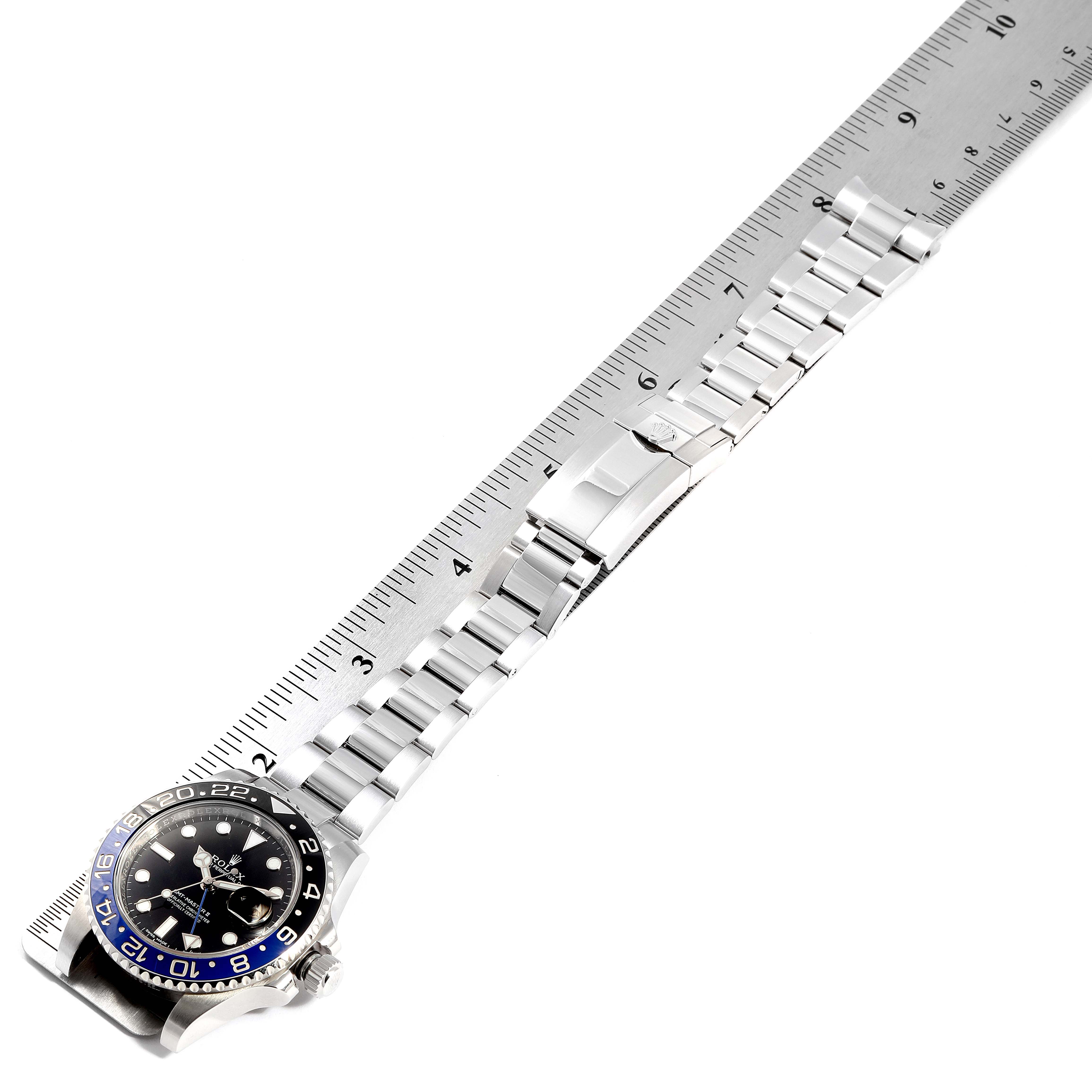 The image shows an overhead view of a Rolex GMT-Master 116710 Men
s Stainless Steel Black Dial 116710 Men
s Stainless Steel Black Dial watch next to a ruler, displaying the watch face, bezel, and bracelet.