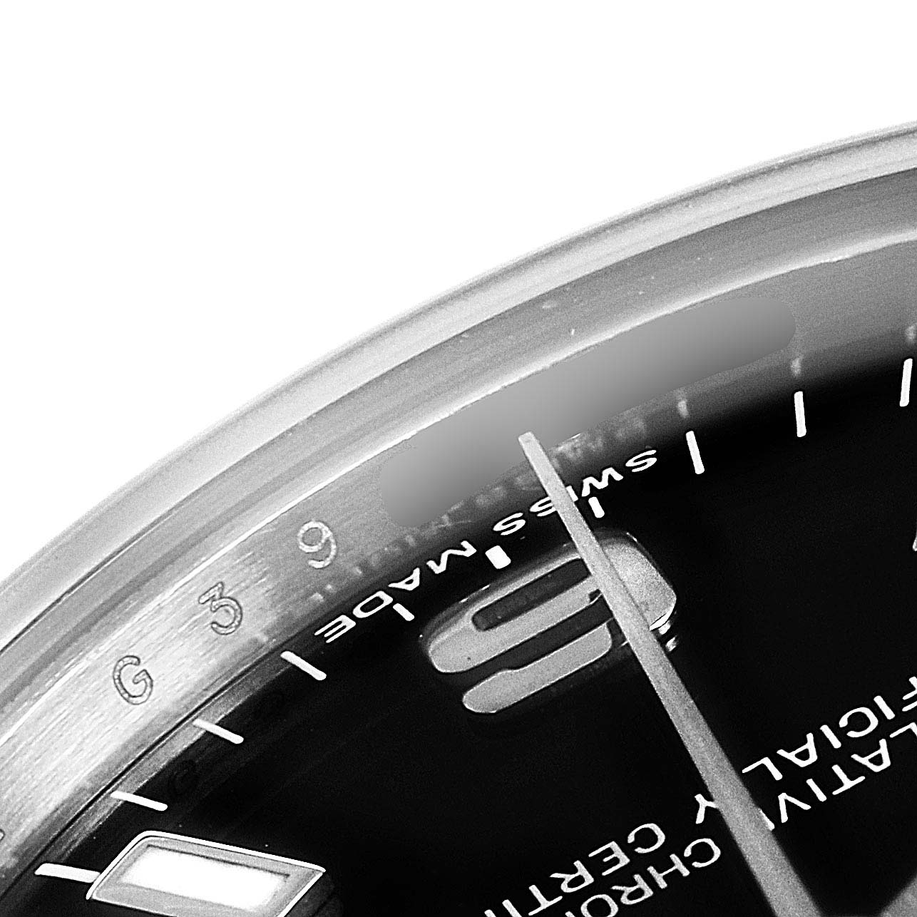 The image shows a close-up of the dial, bezel, and part of the hand of a Mid-Size Rolex watch at an oblique angle.