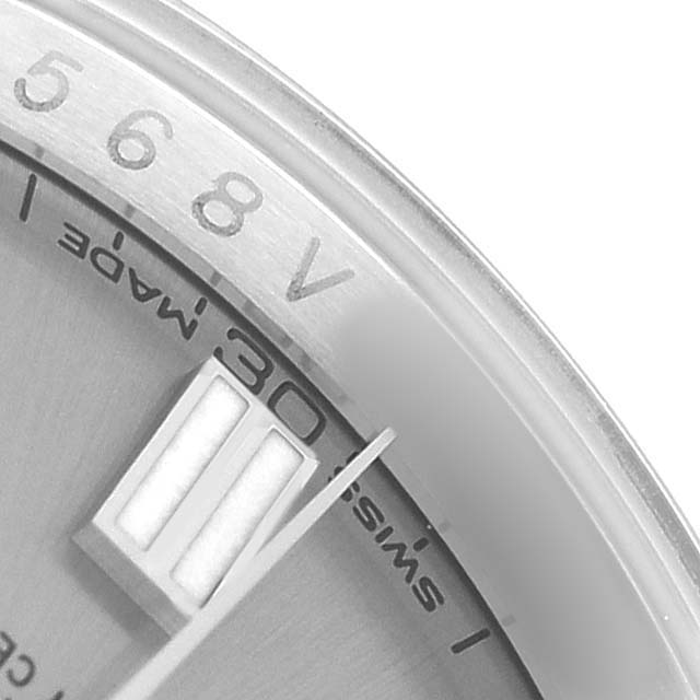 The image shows a close-up of the dial and part of the bezel of a Rolex Oyster Perpetual 116000 Men's Stainless Steel Silver Dial watch.