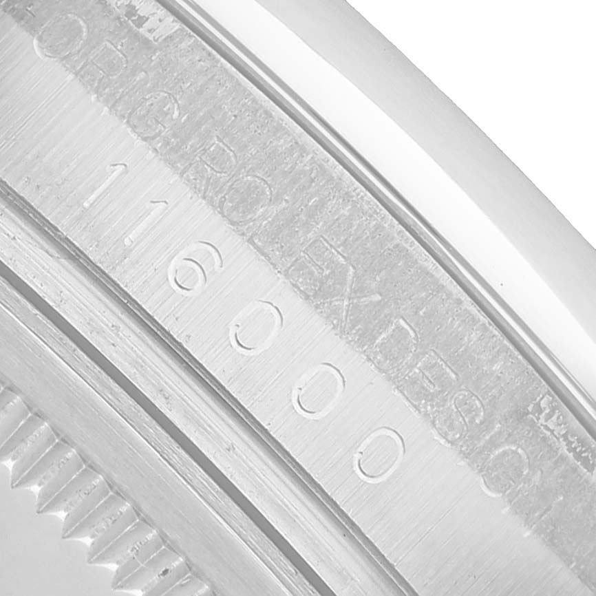 The image shows a close-up of the model number engraving on the side of the Rolex Oyster Perpetual 116000 Men's Stainless Steel Silver Dial watch case.