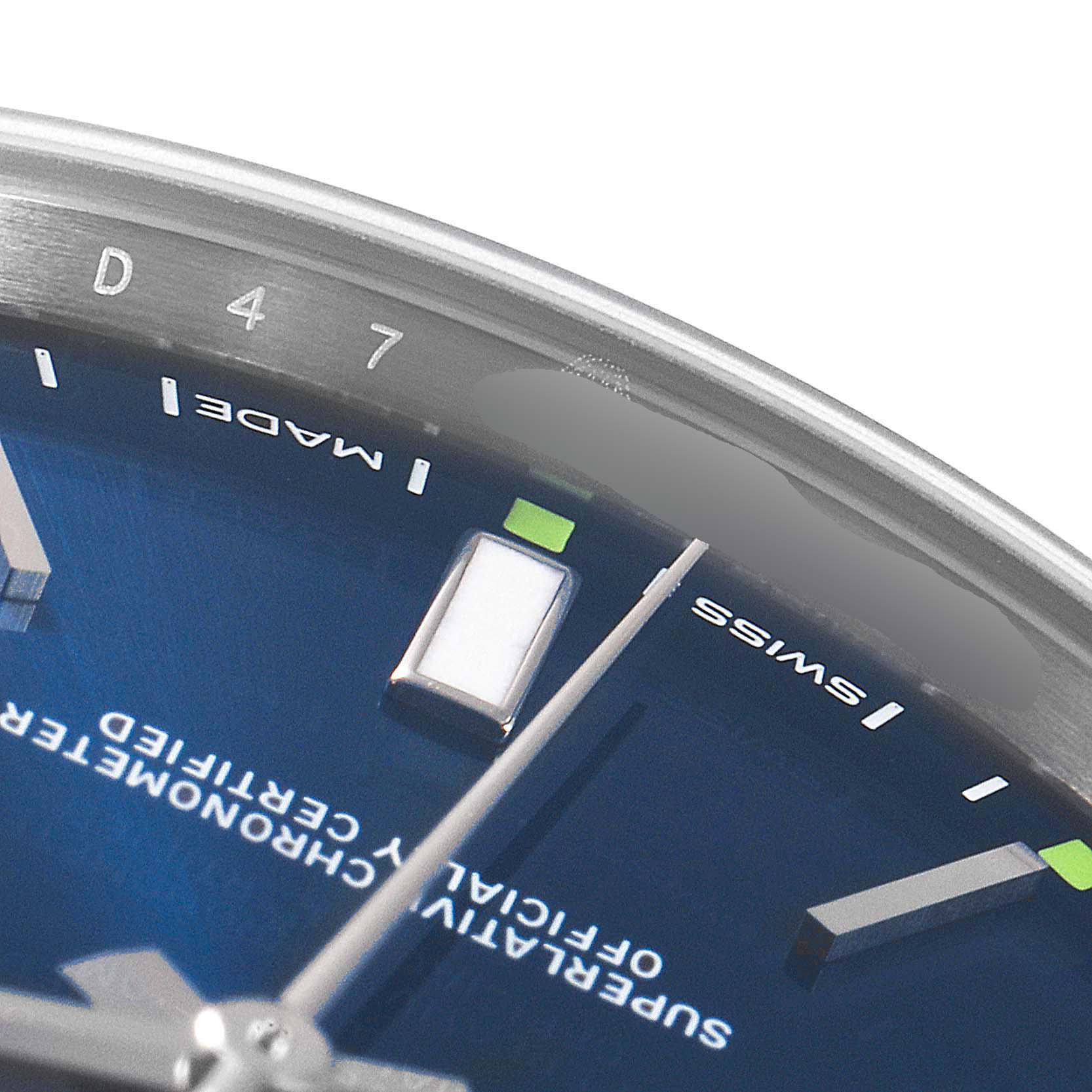 The image shows a close-up of the dial, hands, indices, and part of the bezel of the Rolex Oyster Perpetual 114300 Men's Stainless Steel Blue Dial 114300 Men's Stainless Steel Blue Dial watch.