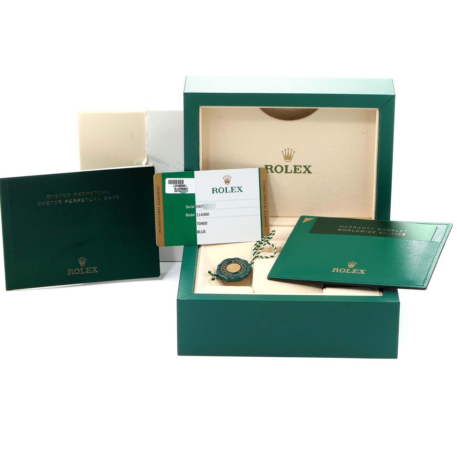 The image shows packaging, documents, and a tag for a Rolex Oyster Perpetual 114300 Men's Stainless Steel Blue Dial 114300 Men's Stainless Steel Blue Dial model watch.