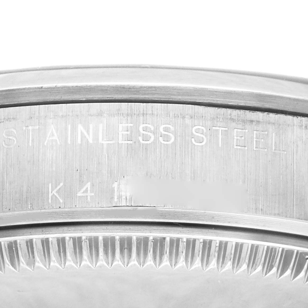 This image shows the detailed edge and engraved markings on the stainless steel case back of a Mid-Size Rolex watch.