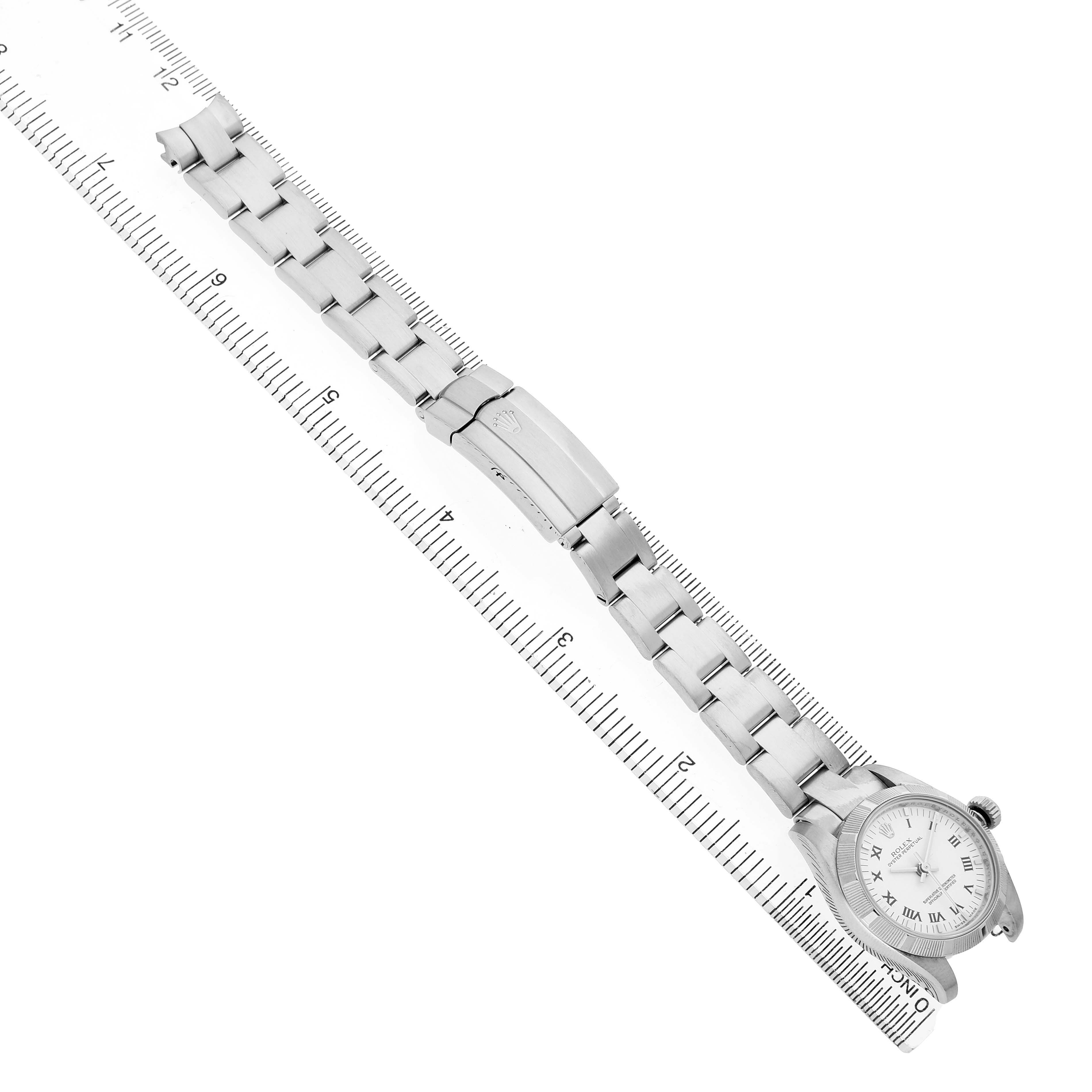 The Rolex Oyster Perpetual 176210 Women's Stainless Steel White Dial watch is shown flat with its bracelet extended alongside a ruler for size reference.