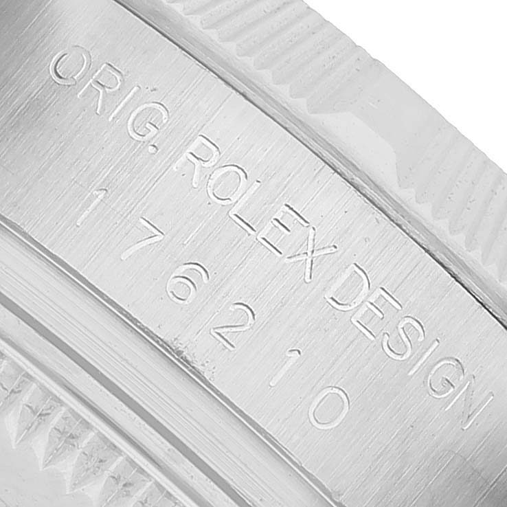 The image shows a close-up of the Rolex Oyster Perpetual 176210 Women's Stainless Steel White Dial model's case, highlighting engraved details and part of the bezel.