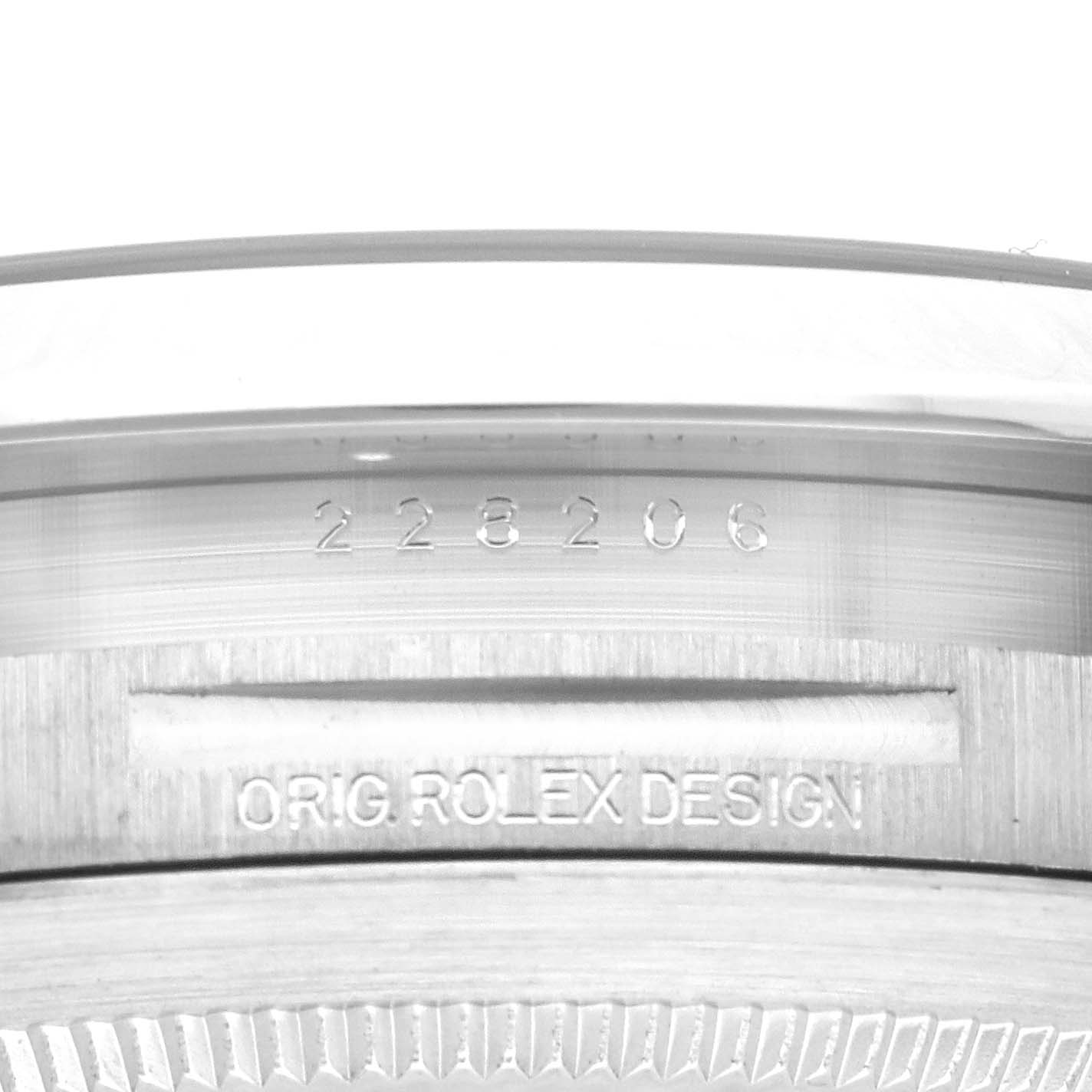 The image shows a close-up of the serial number and "ORIG ROLEX DESIGN" engraving on the case of a Rolex President 228206 Men
s Platinum Blue Dial 228206 Men
s Platinum Blue Dial model watch.