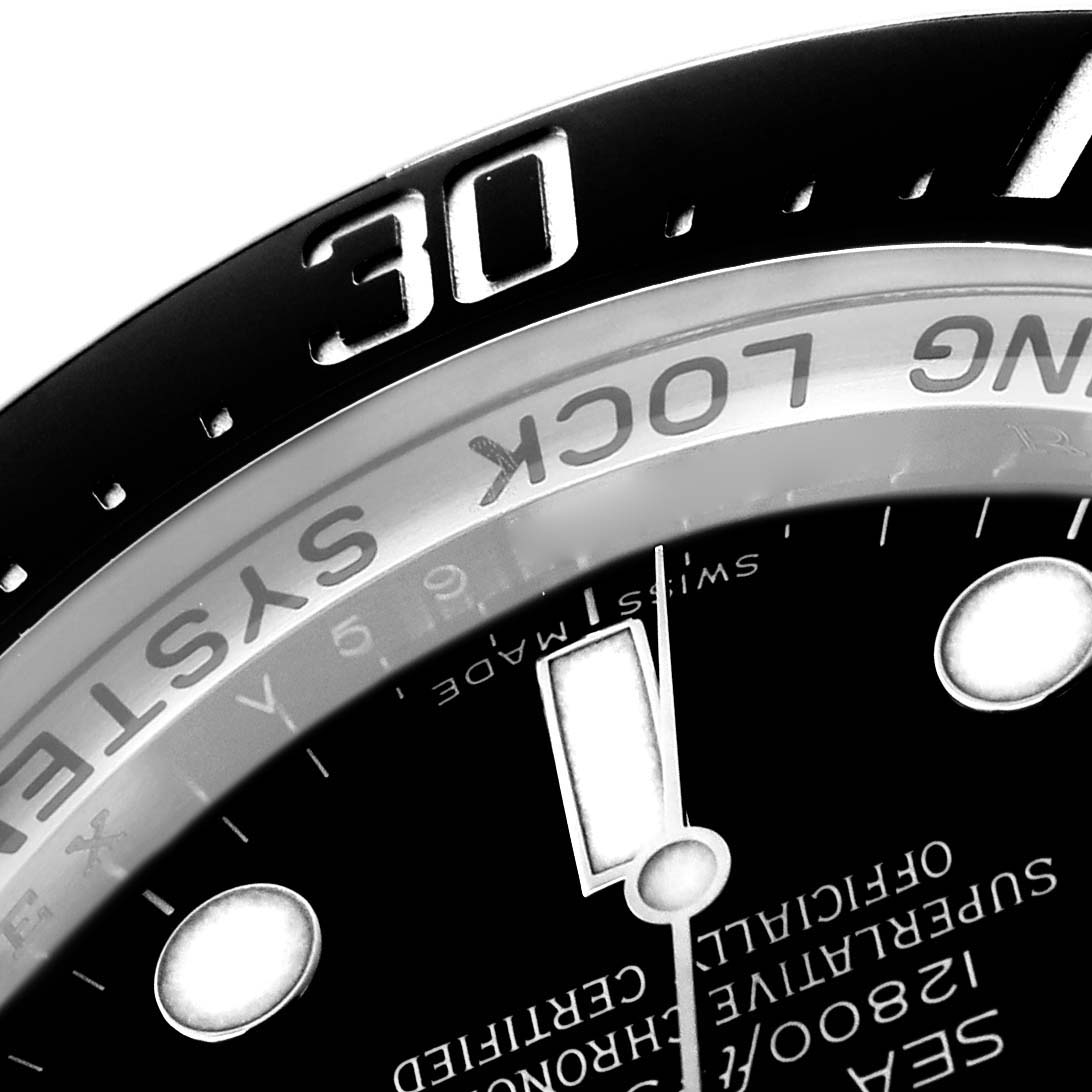 This close-up image of a Rolex Sea-Dweller 116660 Men
s Stainless Steel Black Dial shows part of the dial, bezel with the "30" mark, and text detailing.
