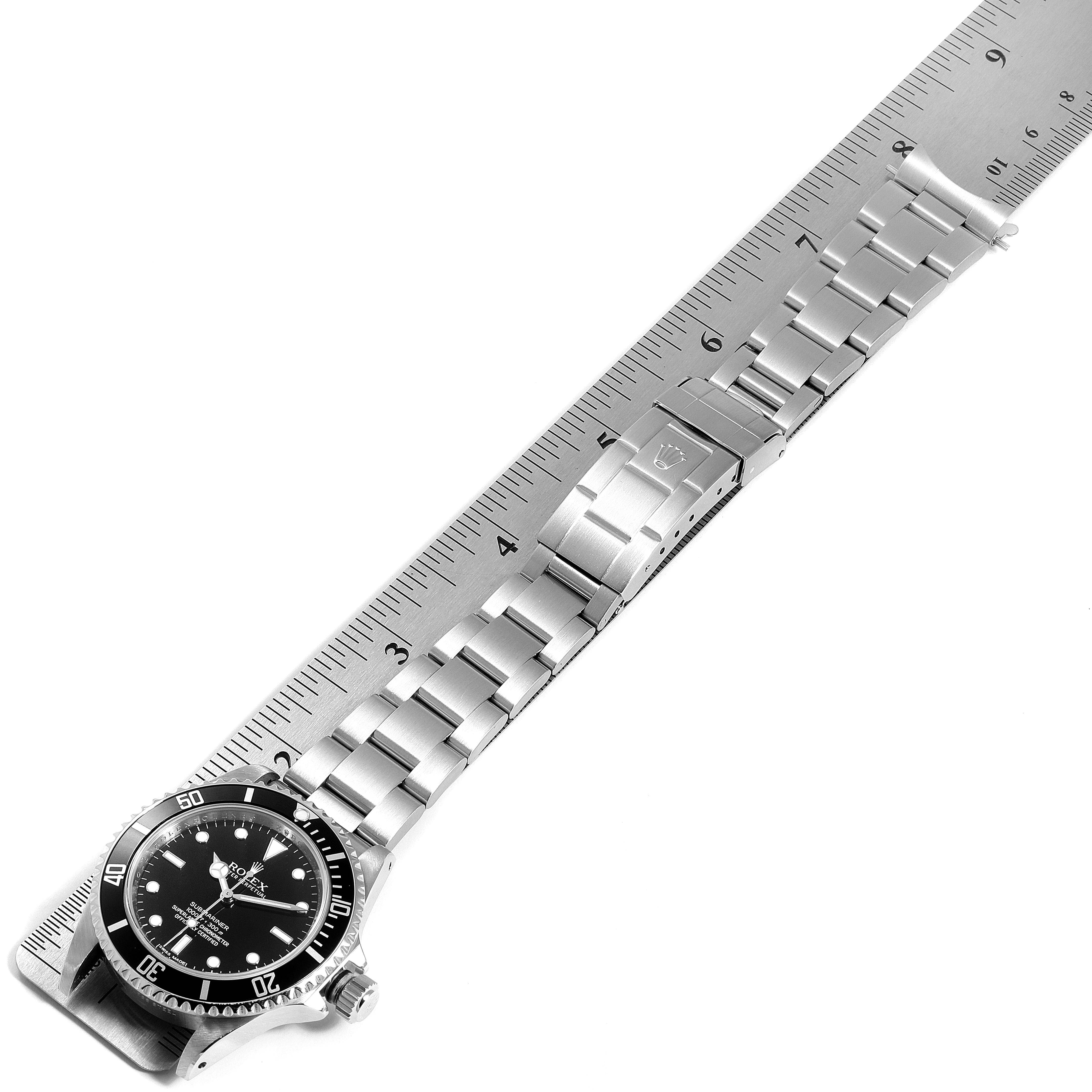 This image shows the full length of a Rolex Submariner 14060 Men's Stainless Steel Black Dial 14060 Men's Stainless Steel Black Dial watch, including its face, bezel, and bracelet, laid next to a ruler.