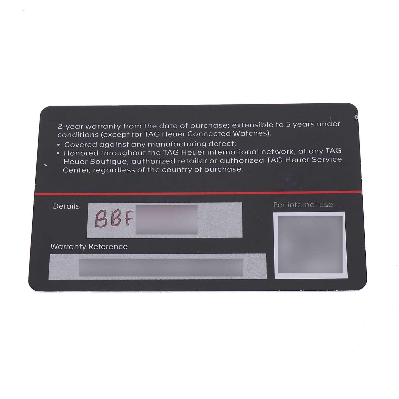This image shows a TAG Heuer warranty card for the Monaco model, angled flat and displaying warranty details and reference sections.