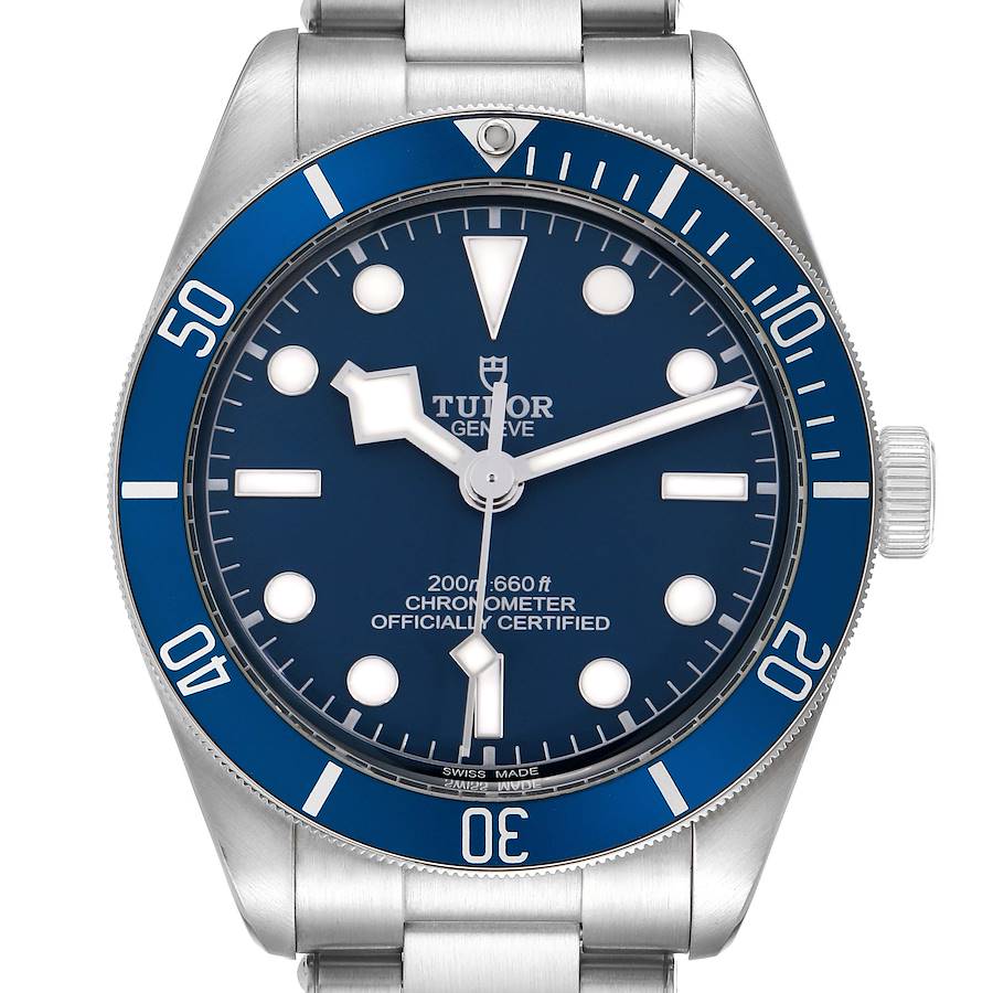 The image shows a front view of the Tudor Heritage Black Bay model 79030B, highlighting the blue bezel, dial, and silver bracelet.