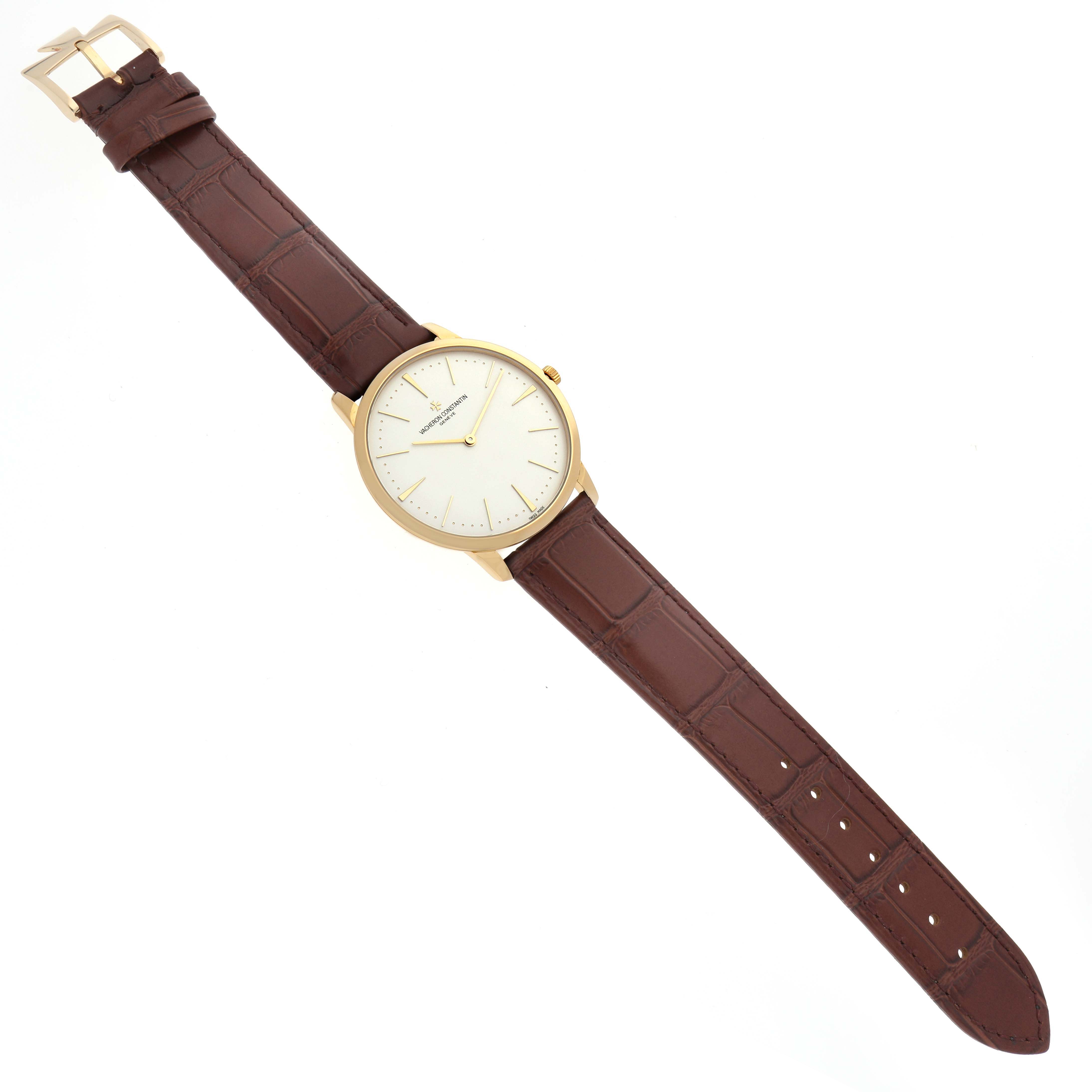 This image shows a Vacheron Constantin Patrimony 81180/000J-9118 Men's Yellow Gold Silver Dial 81180/000J-9118 Men's Yellow Gold Silver Dial watch, captured from an overhead angle, displaying its face, brown leather strap, and buckle.