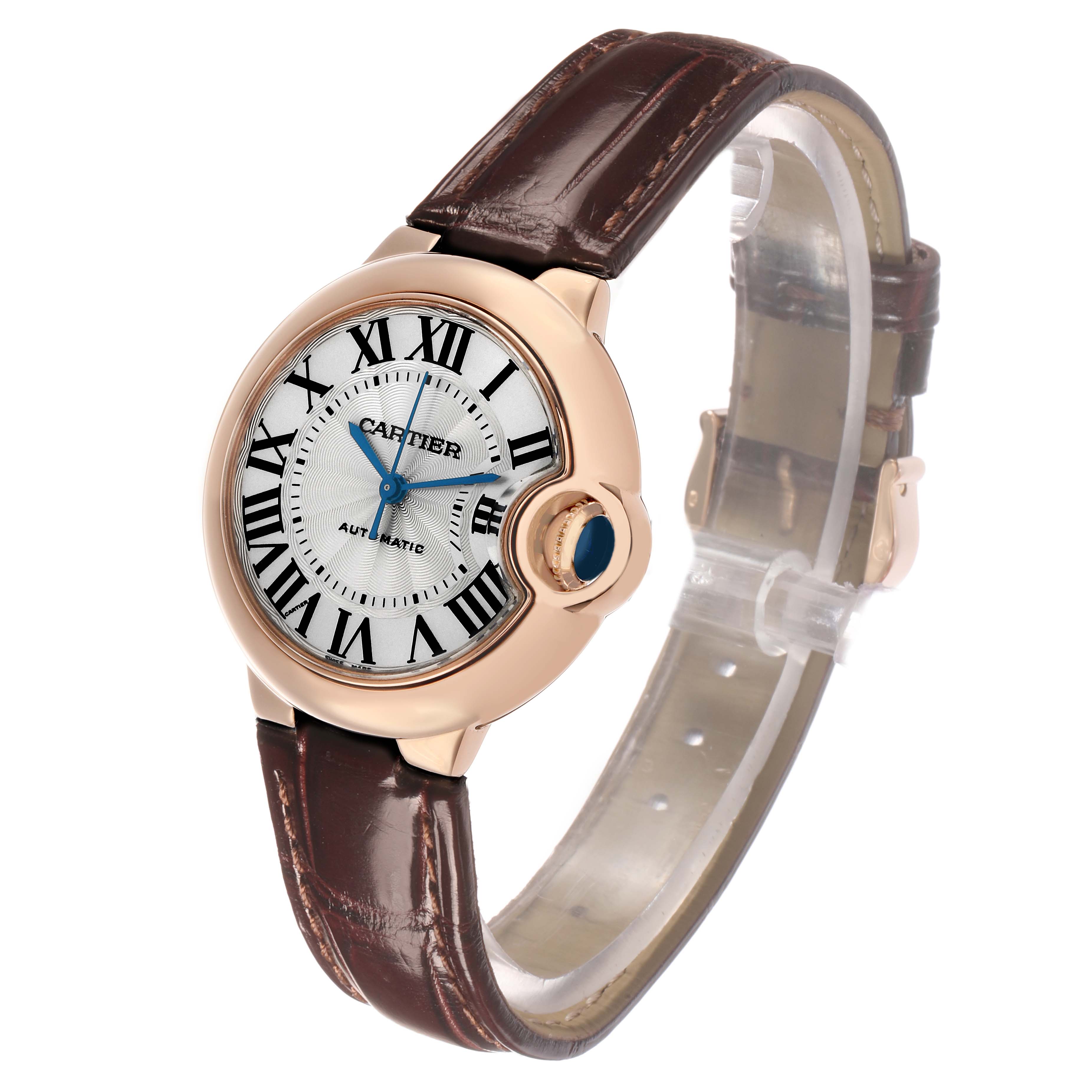 The Cartier Ballon Bleu W6920097 Women's Rose Gold Silver Dial watch is shown at an angled side view, highlighting the face, Roman numerals, crown, and leather strap.