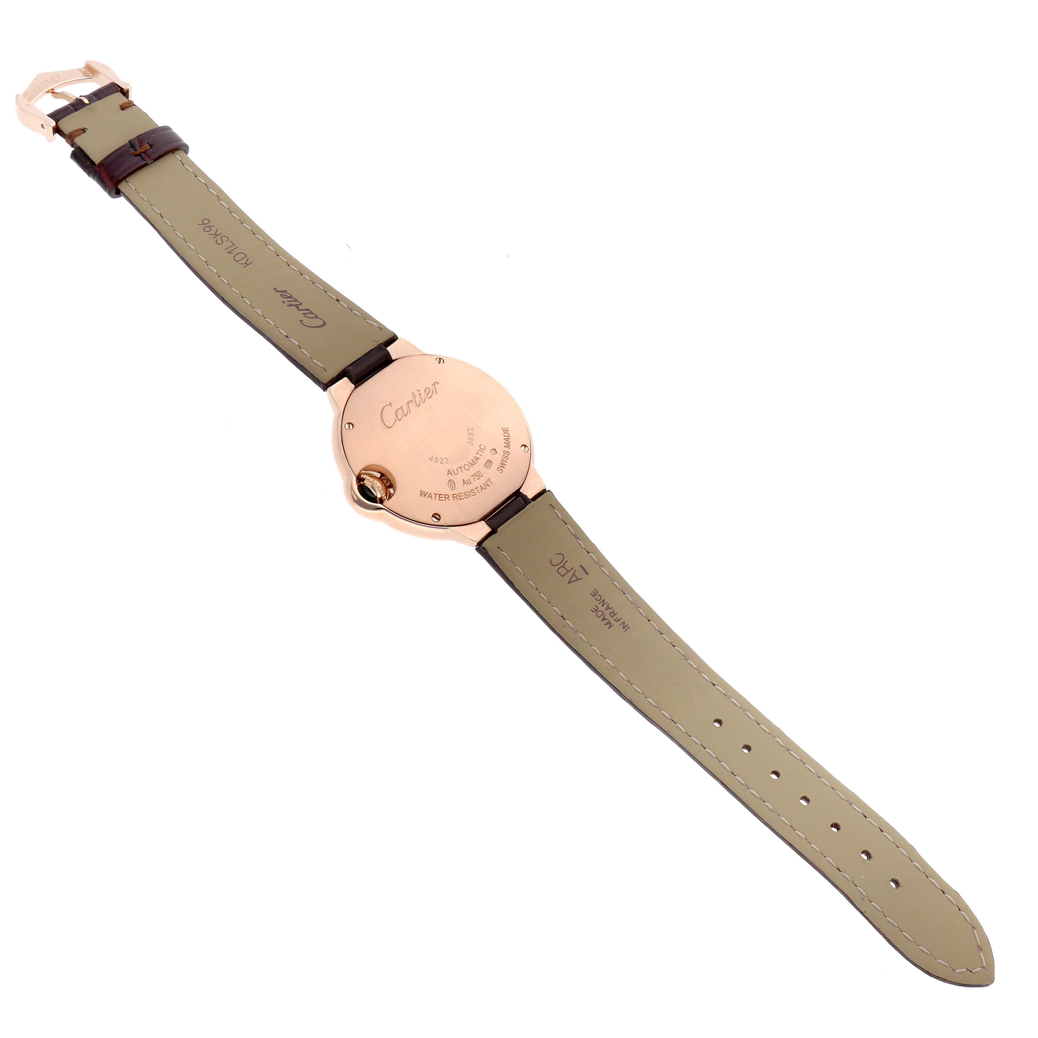 The watch is a Cartier Ballon Bleu W6920097 Women's Rose Gold Silver Dial, shown from the back, highlighting the case back, leather strap, and buckle.