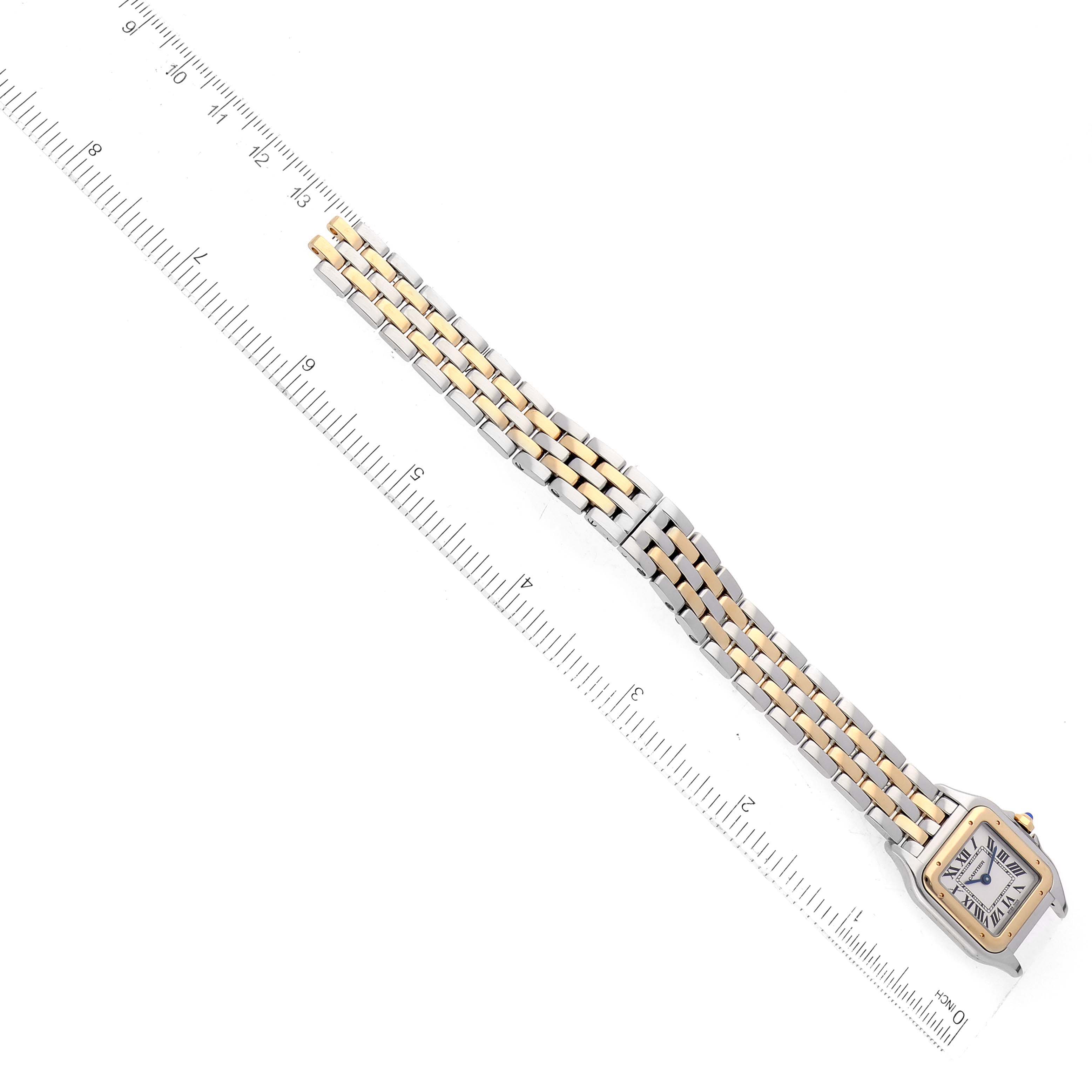 A Panthere model by Cartier is shown from an overhead angle, displaying the full watch and its two-tone metal bracelet next to a ruler.